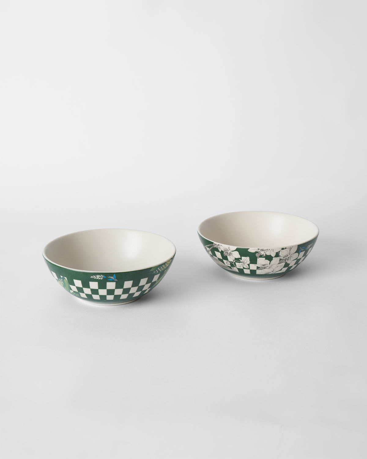 Two Reesha bowls with green checkered bands, birds, and white floral motifs.