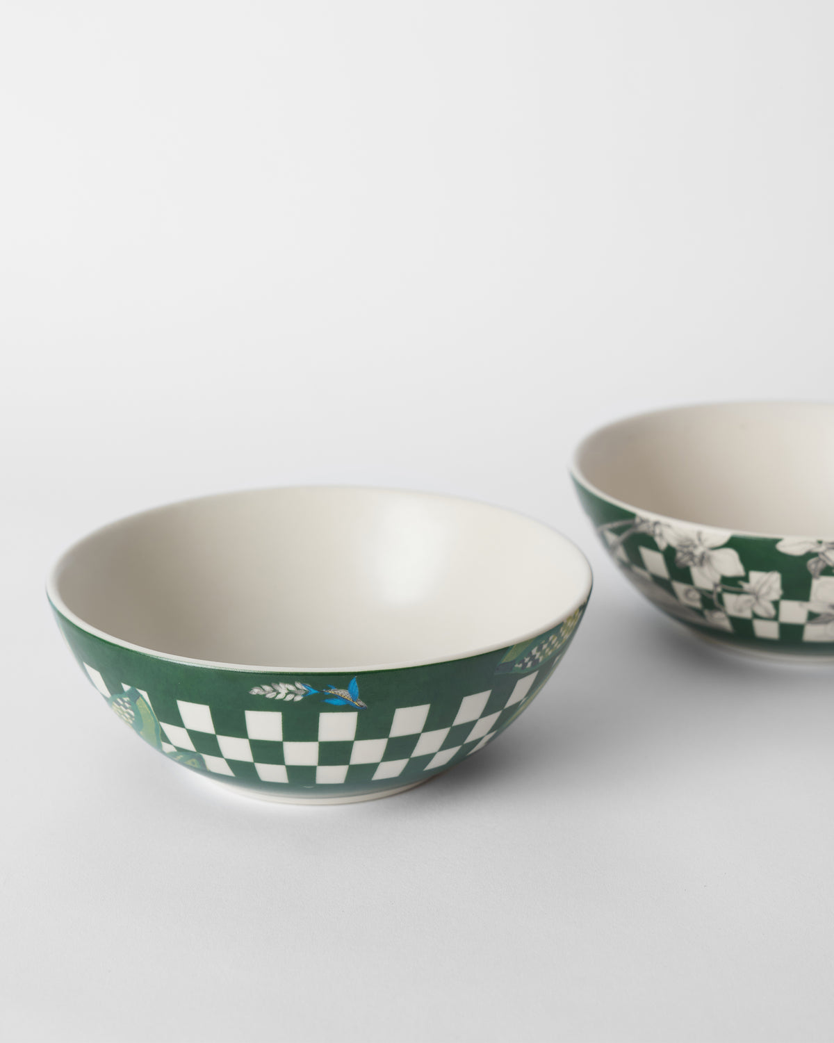 Overhead view of Reesha bowls with cream interiors and a blue bird motif.