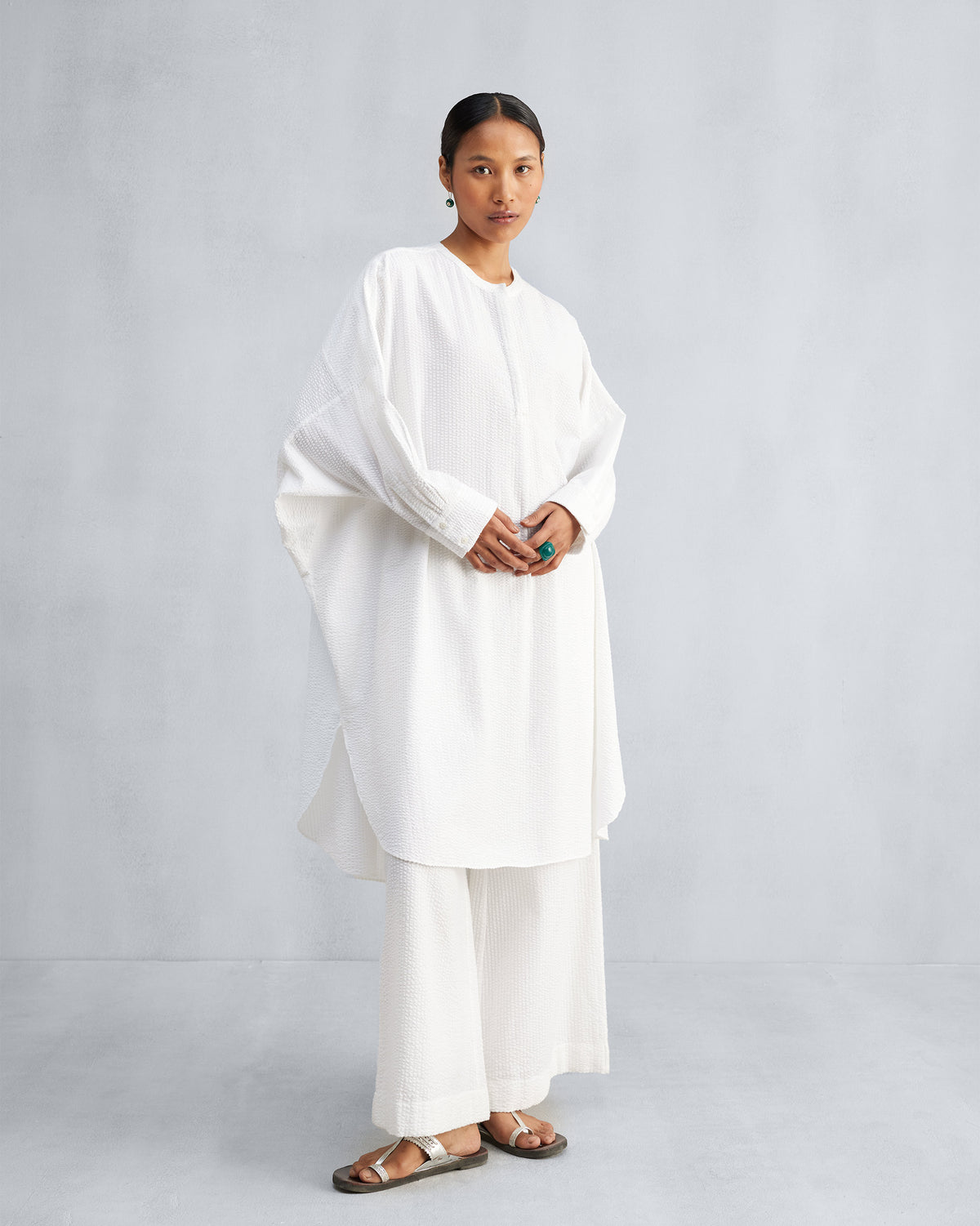 Person wearing a white Lazy Sunday tunic set with a curved hem.