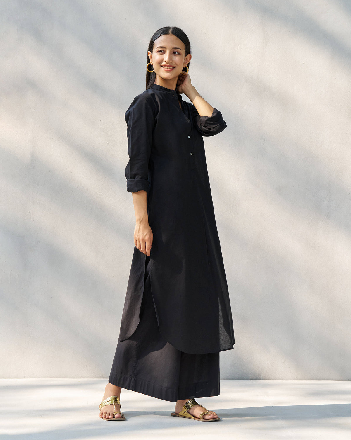 Black long kurta set with a curved hem and wide-leg pants.