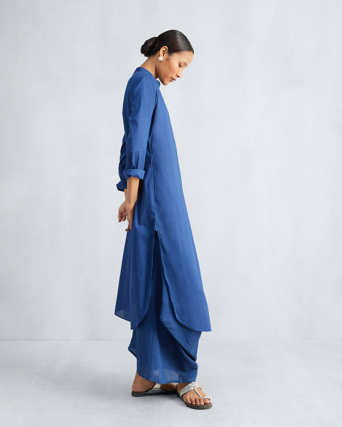 Side view of a navy long kurta set showing high side slits and a curved hem.