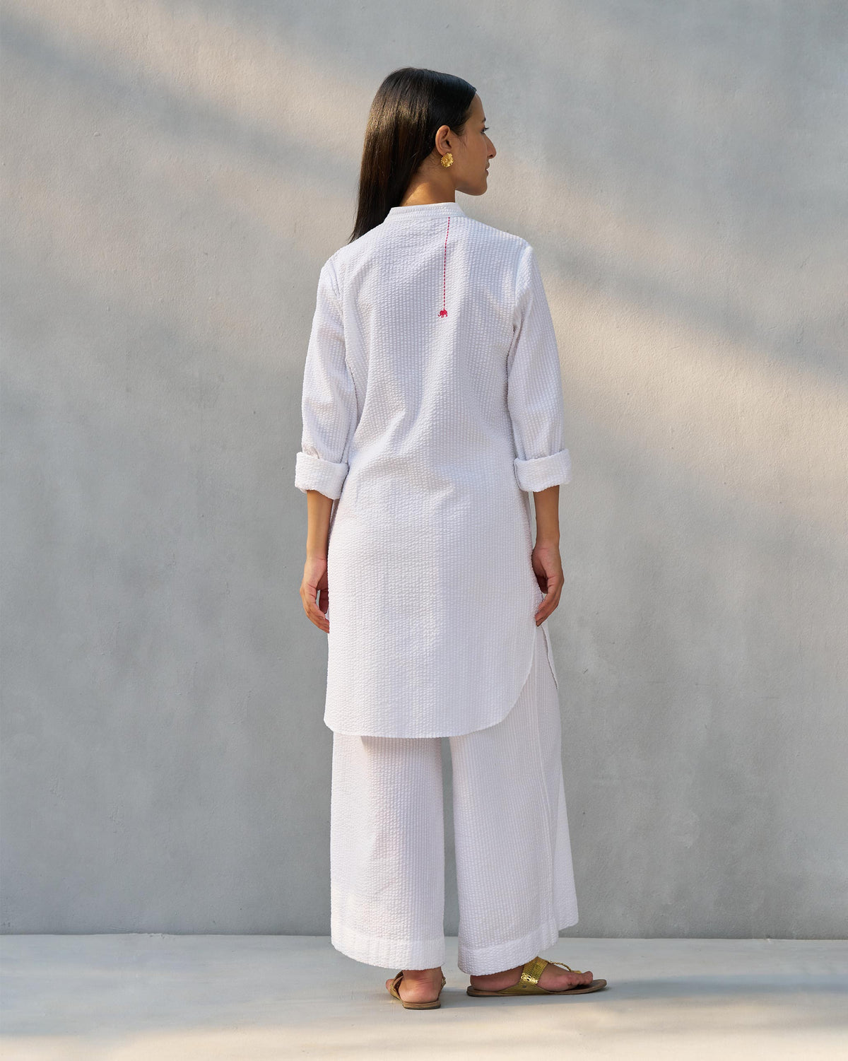 Back of a white seersucker Ice Set kurta with matching wide-leg pants.