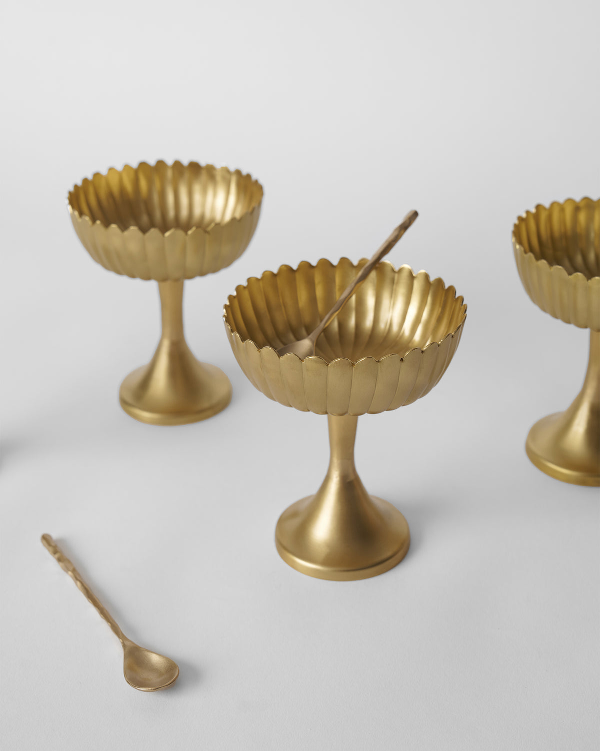 Gold Dhaara Gelato Cups with scalloped rims and twig-handle spoons.