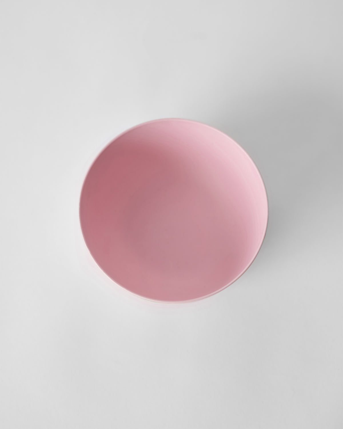 Overhead view of a solid pink Toucan bamboo cereal bowl looking into the well.