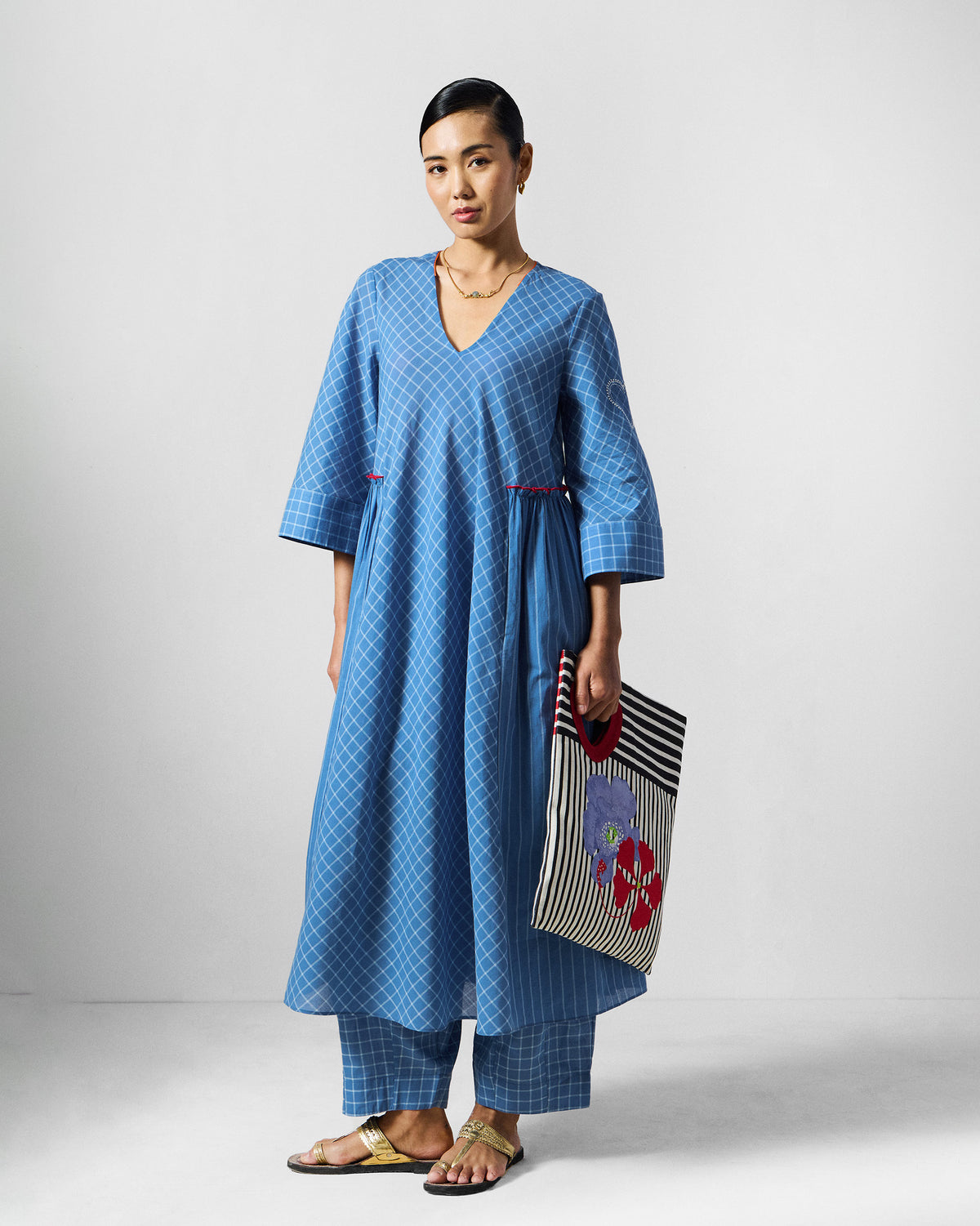 Person wearing the Giri Kurta Set in blue check with a V-neck and three-quarter sleeves.
