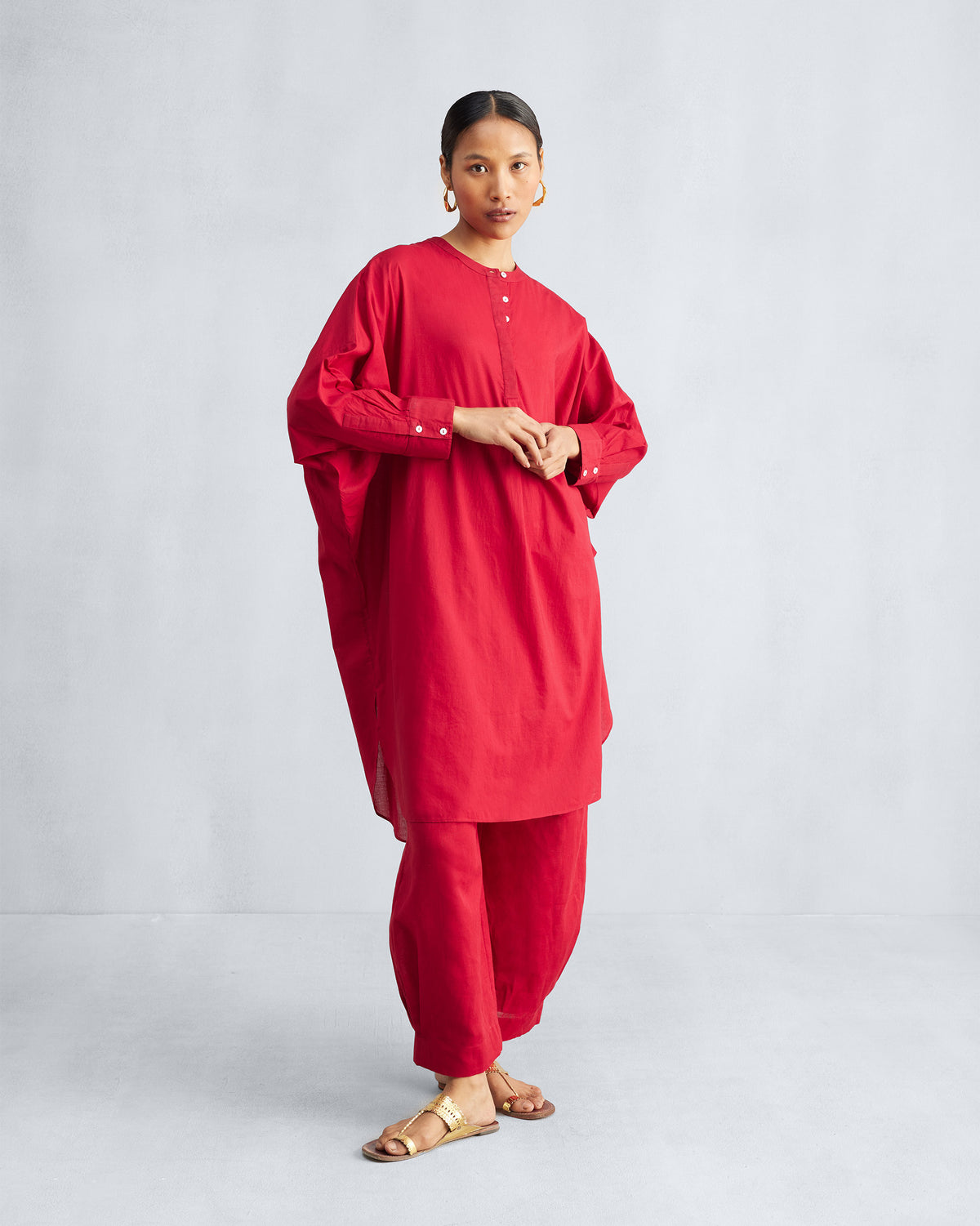Person wearing a red Lazy Sunday tunic with a buttoned mandarin collar.