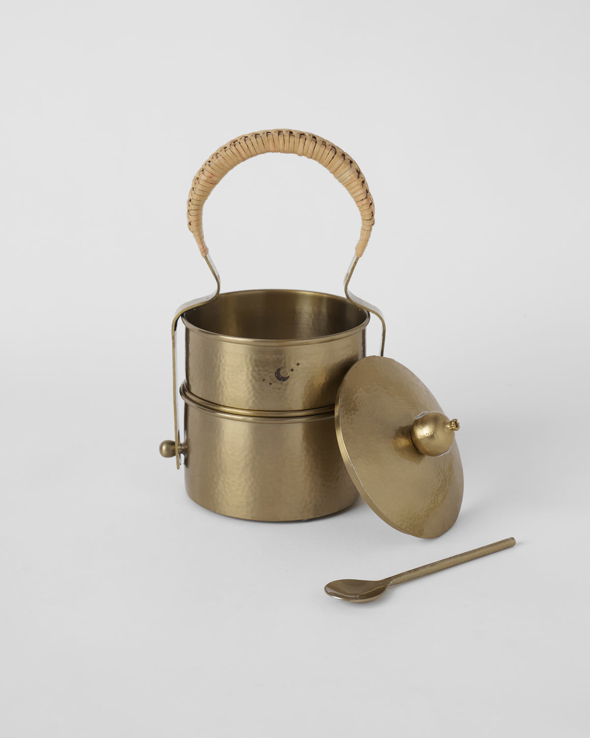 Gold Chand tiffin box with its lid and spoon beside it.