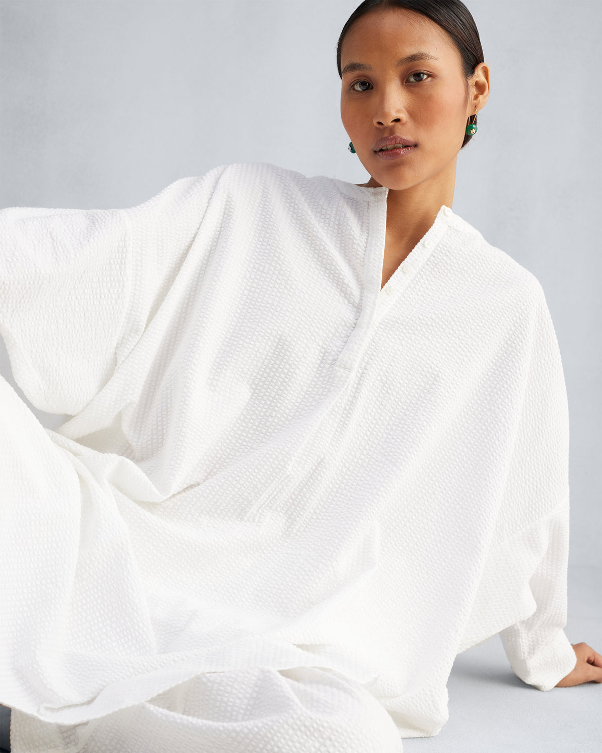 Close-up of a white Lazy Sunday tunic showing textured fabric and sleeves.