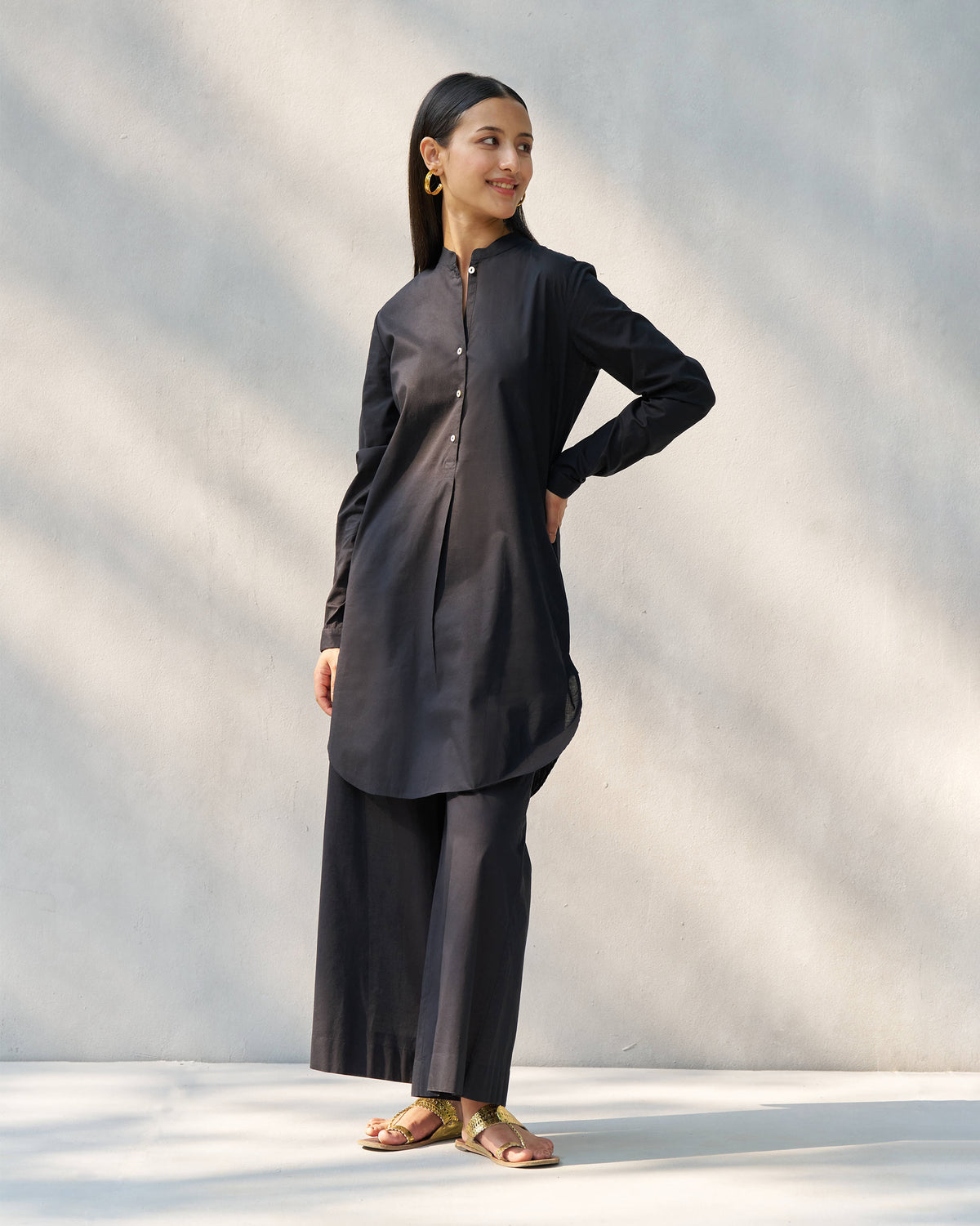 Person wearing a black Stone set tunic and matching wide pants.