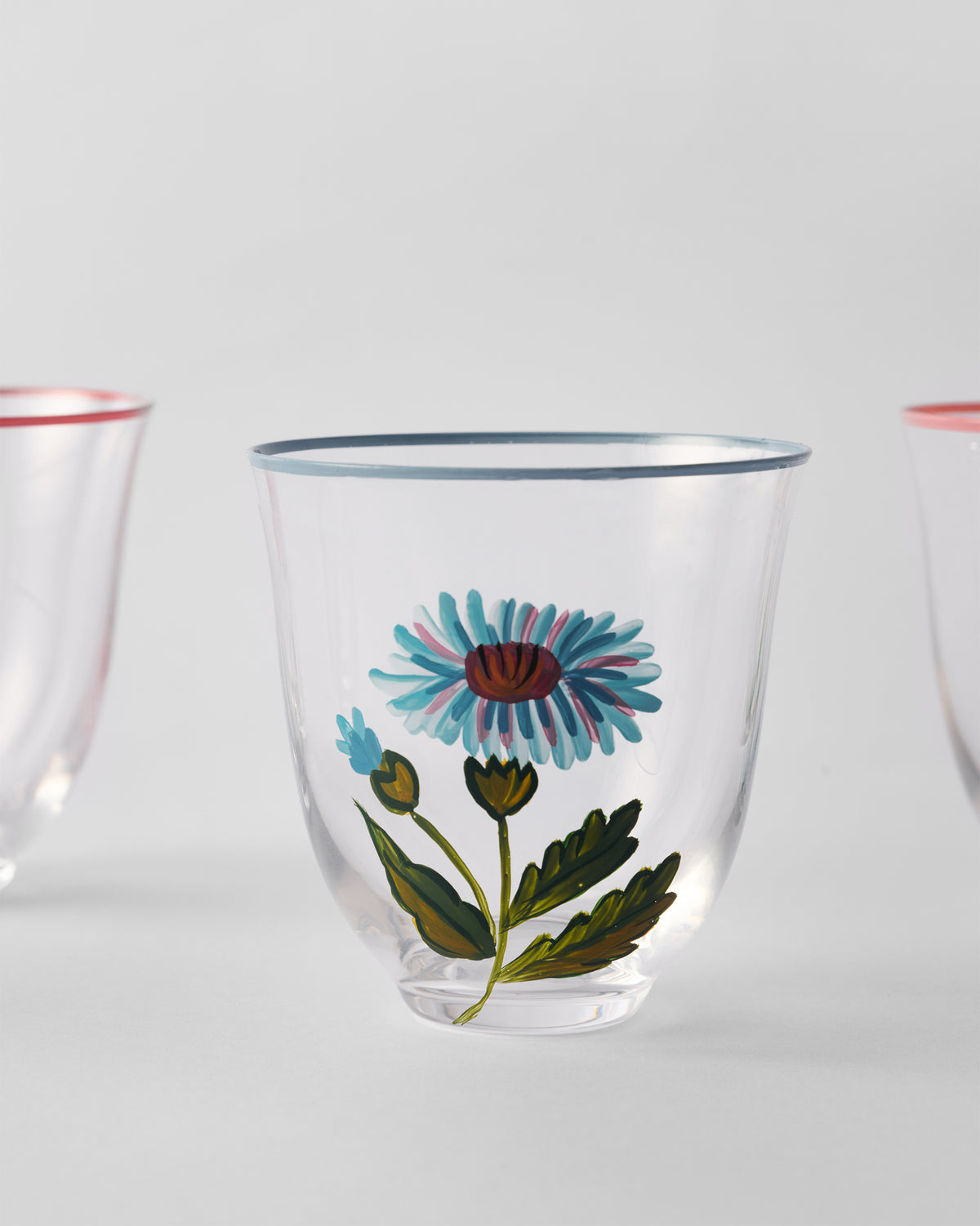 Close-up of a Rit tumbler with a light blue flower motif and blue rim.