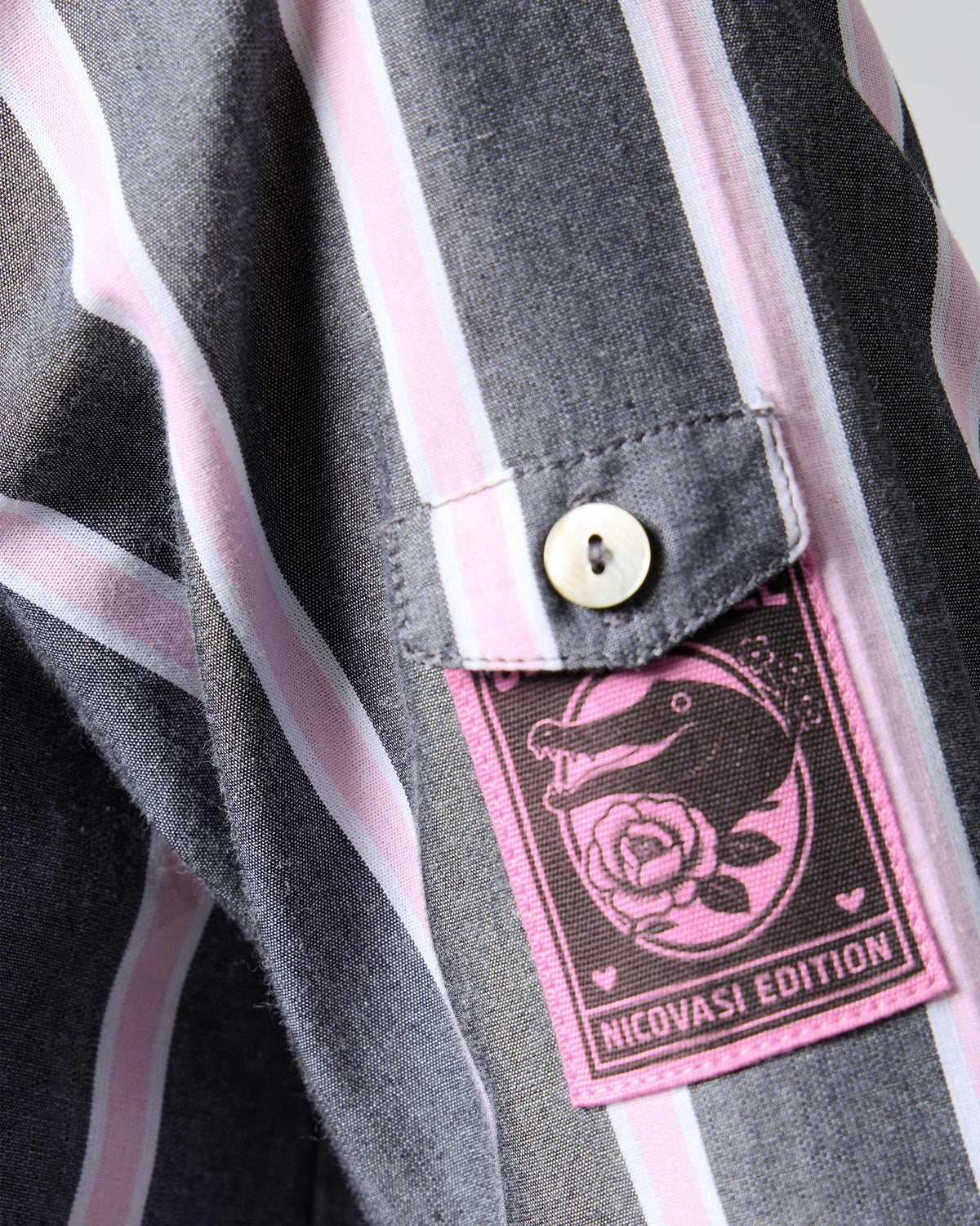 Close-up of a Trench shirt showing a pink Nicovasi Edition sleeve patch.