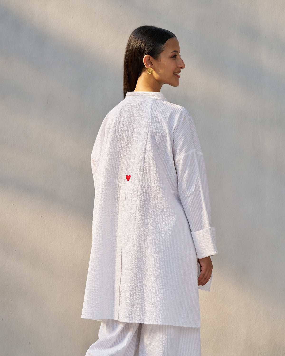 Back of a white seersucker Cirrus shirt with a red embroidered heart.