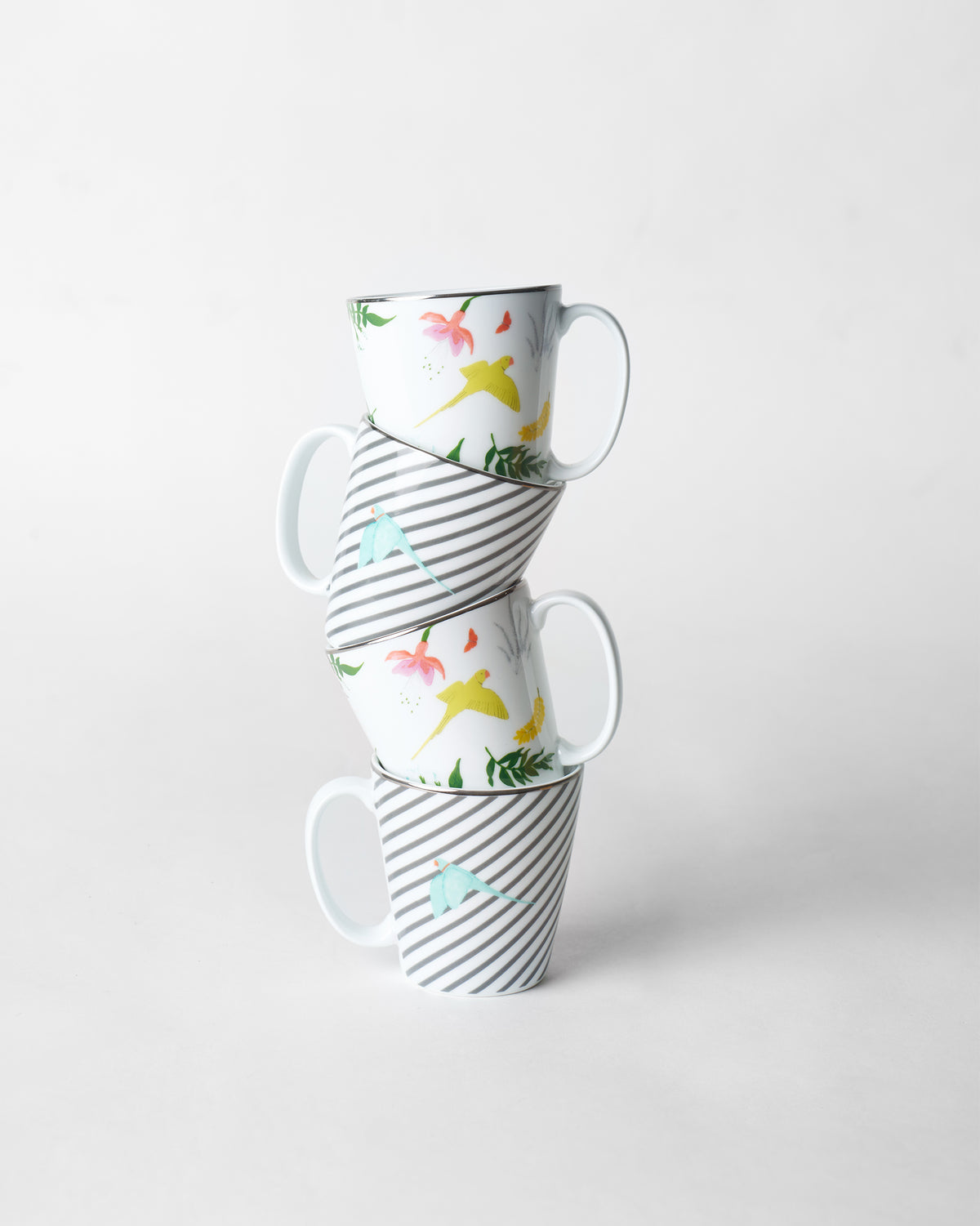 Stack of four Botanical Coffee Mugs alternating tropical and striped bird prints.