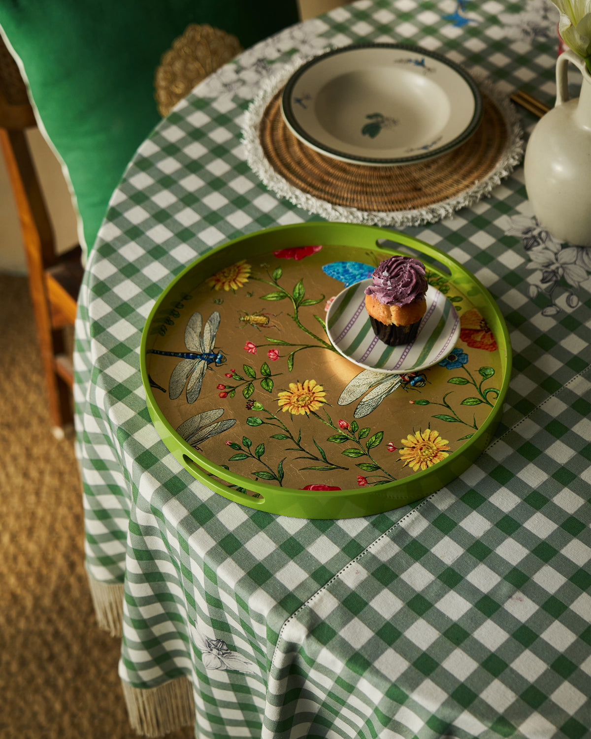 Bloom round tray serving a frosted cupcake on a green checkered tablecloth.