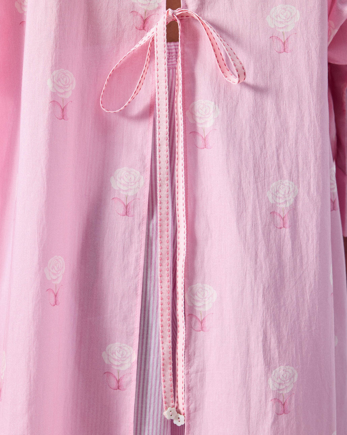 Close-up of striped tie closures on a pink floral tunic.