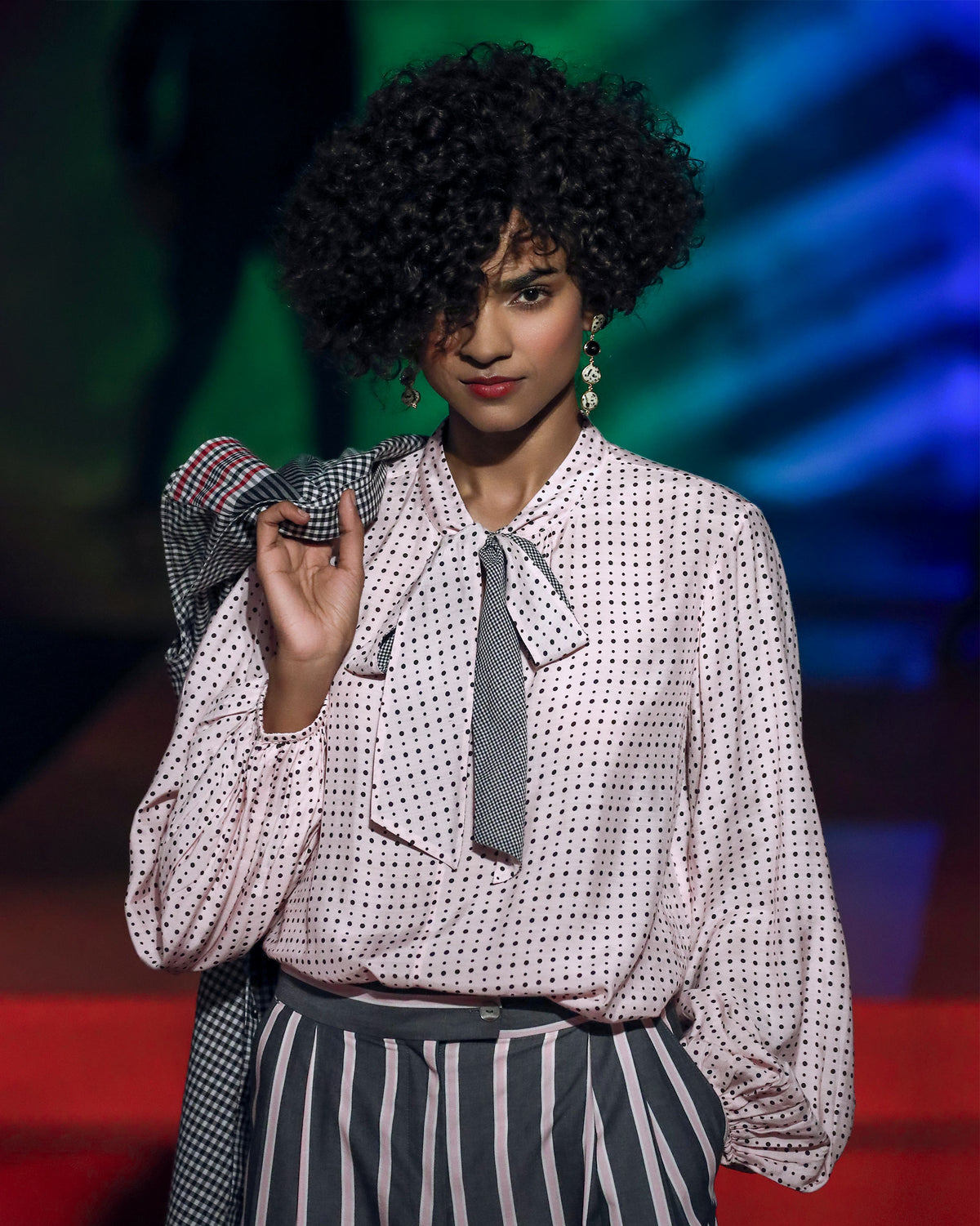 Person wearing a pink polka-dot Spring tie shirt with a pussy-bow.