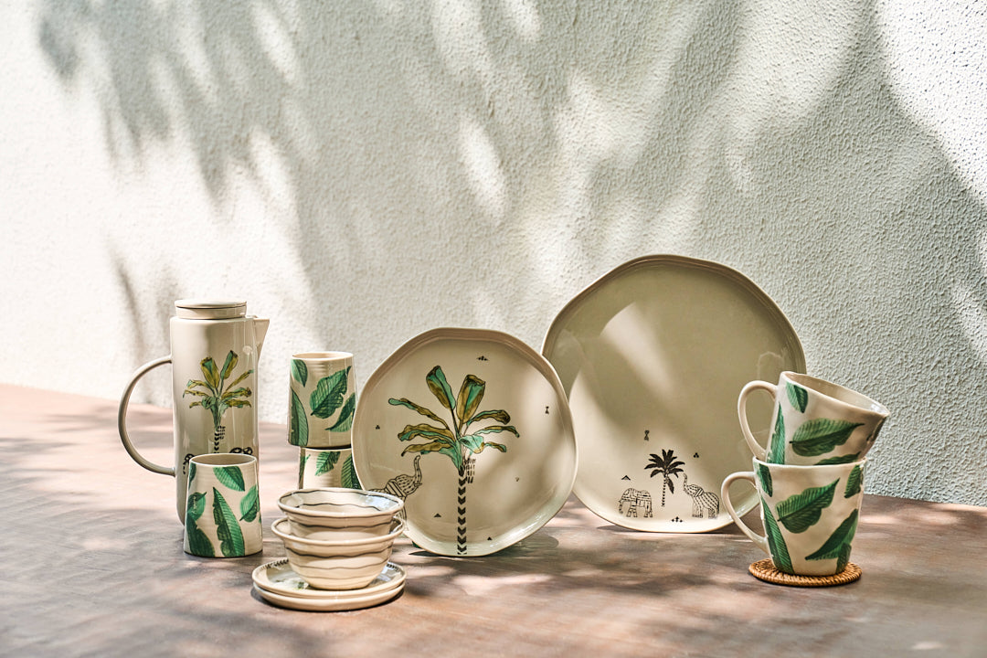 Galle kulhars with green banana leaves among matching tropical tableware.