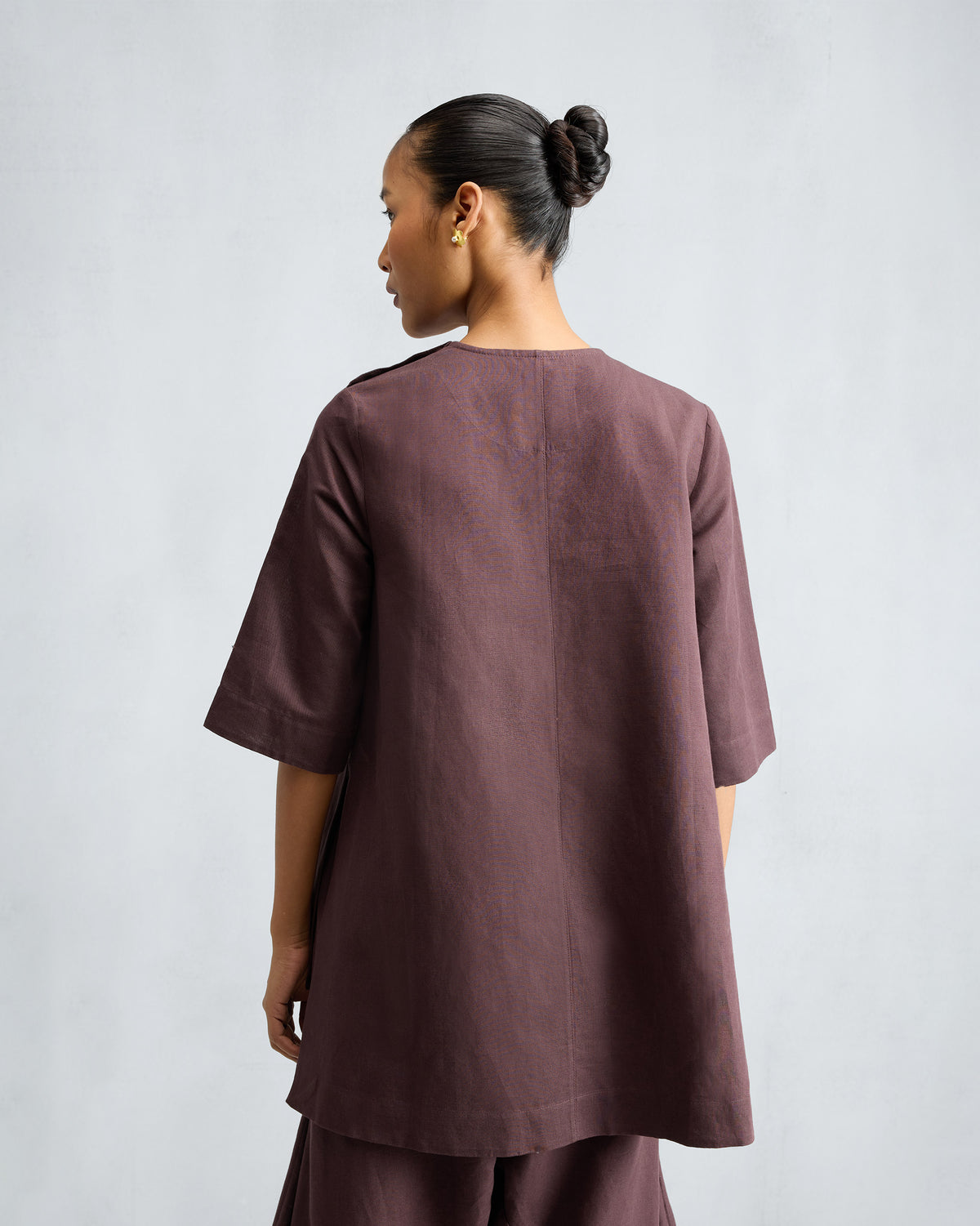 Back of a chocolate plum high slit top with matching pants.