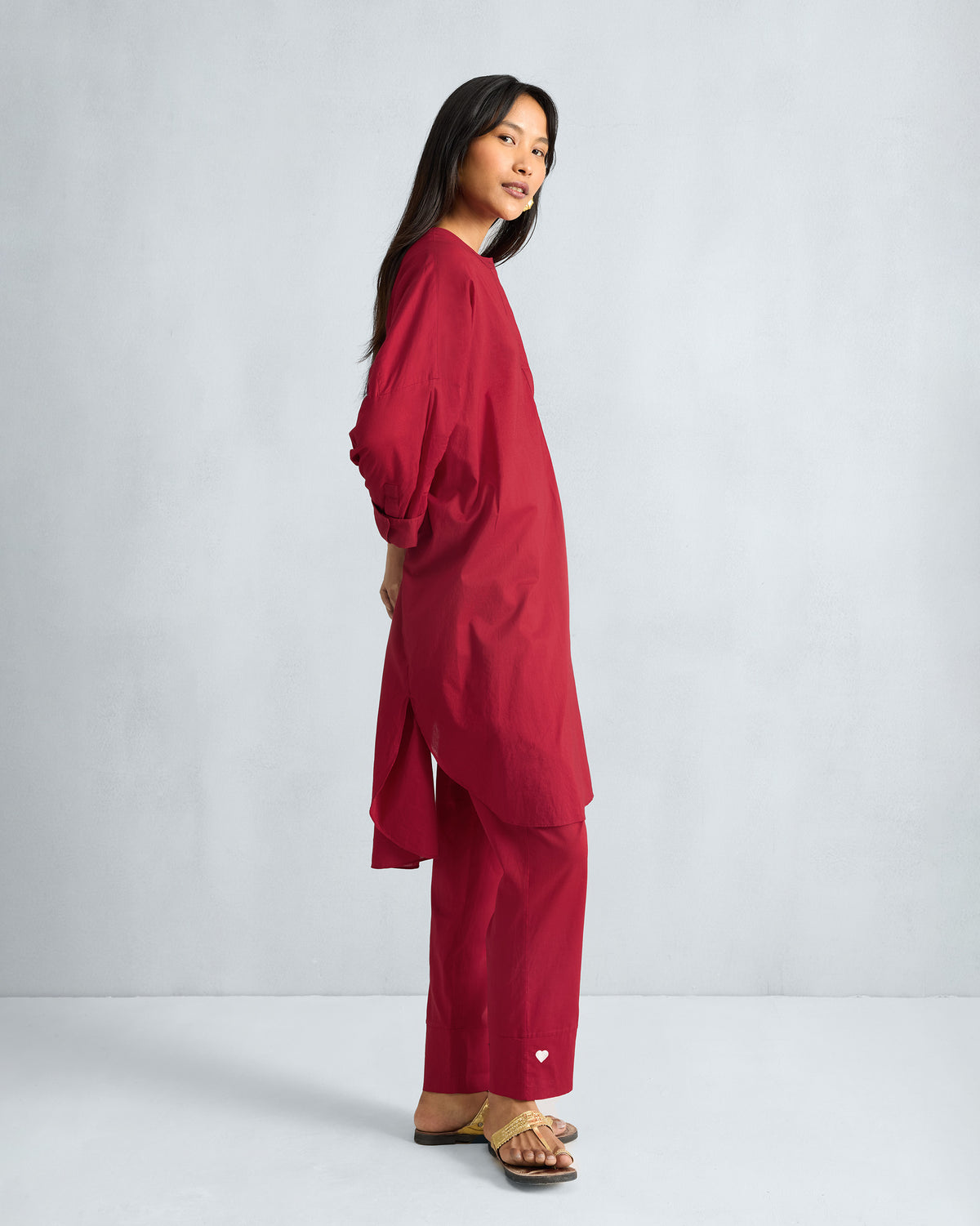 Side view of a red Lazy Sunday tunic set showing the side slit and heart hem.