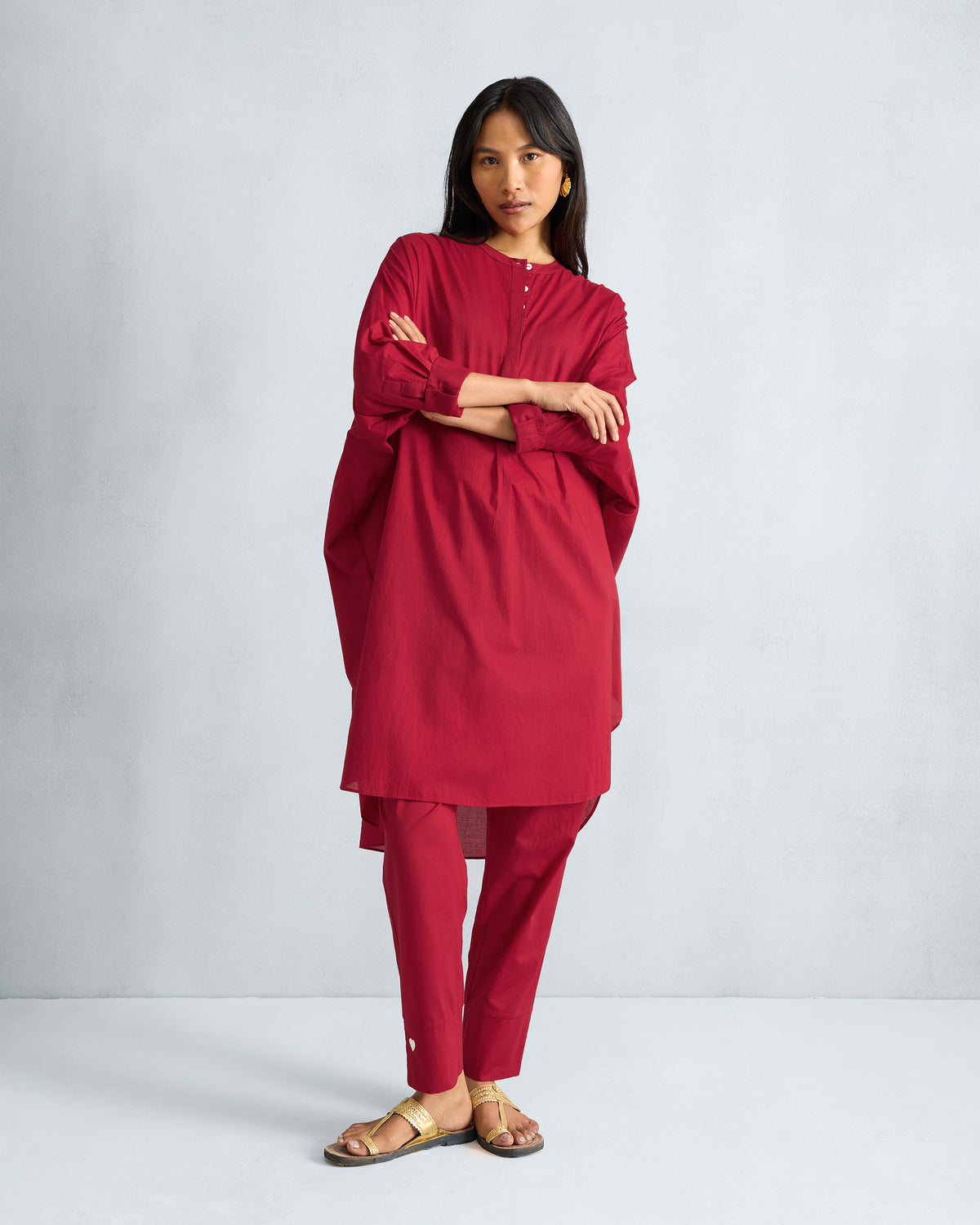 Person wearing a red Lazy Sunday tunic with a buttoned mandarin collar.