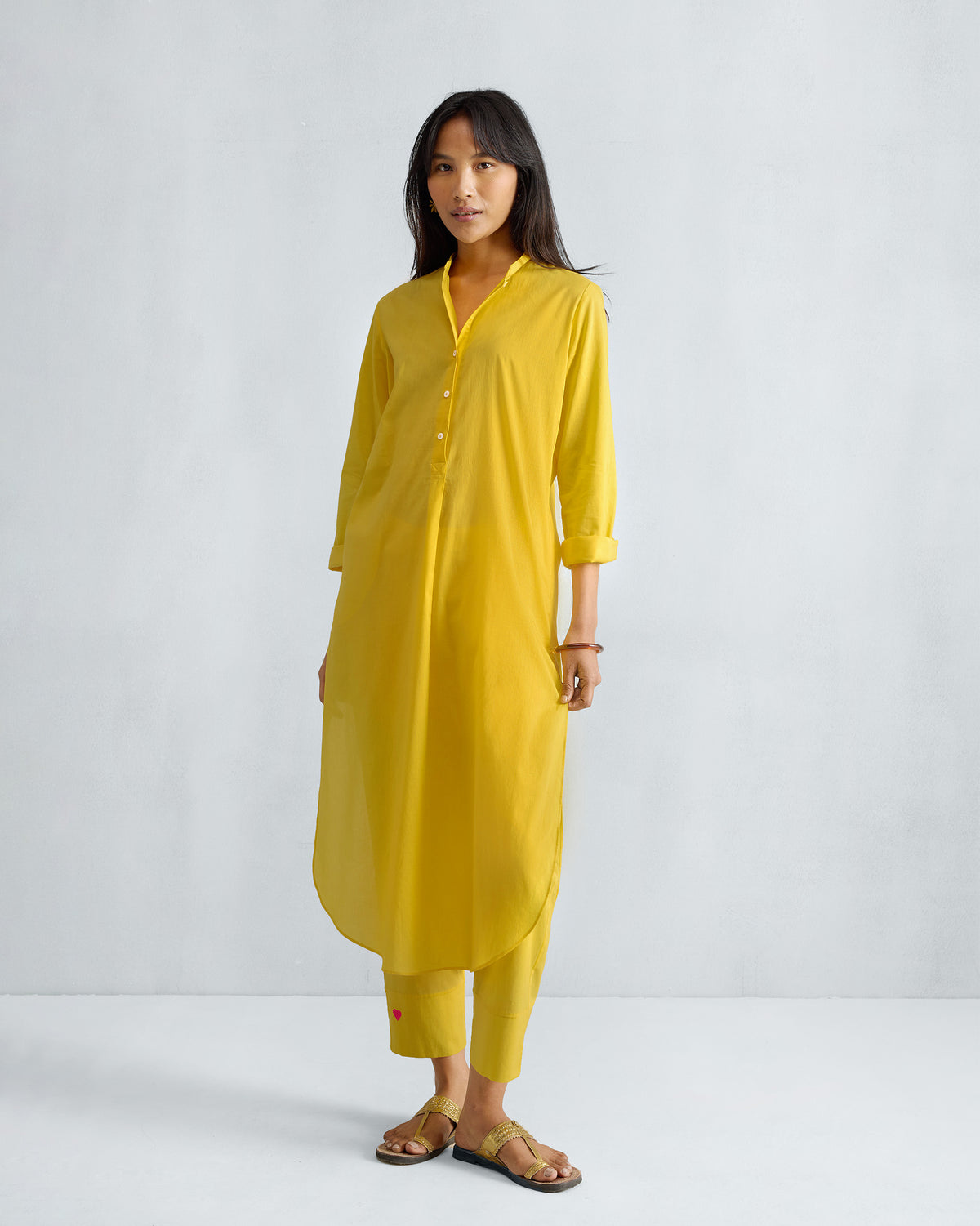 Person wearing a yellow long kurta set with matching cropped pants.