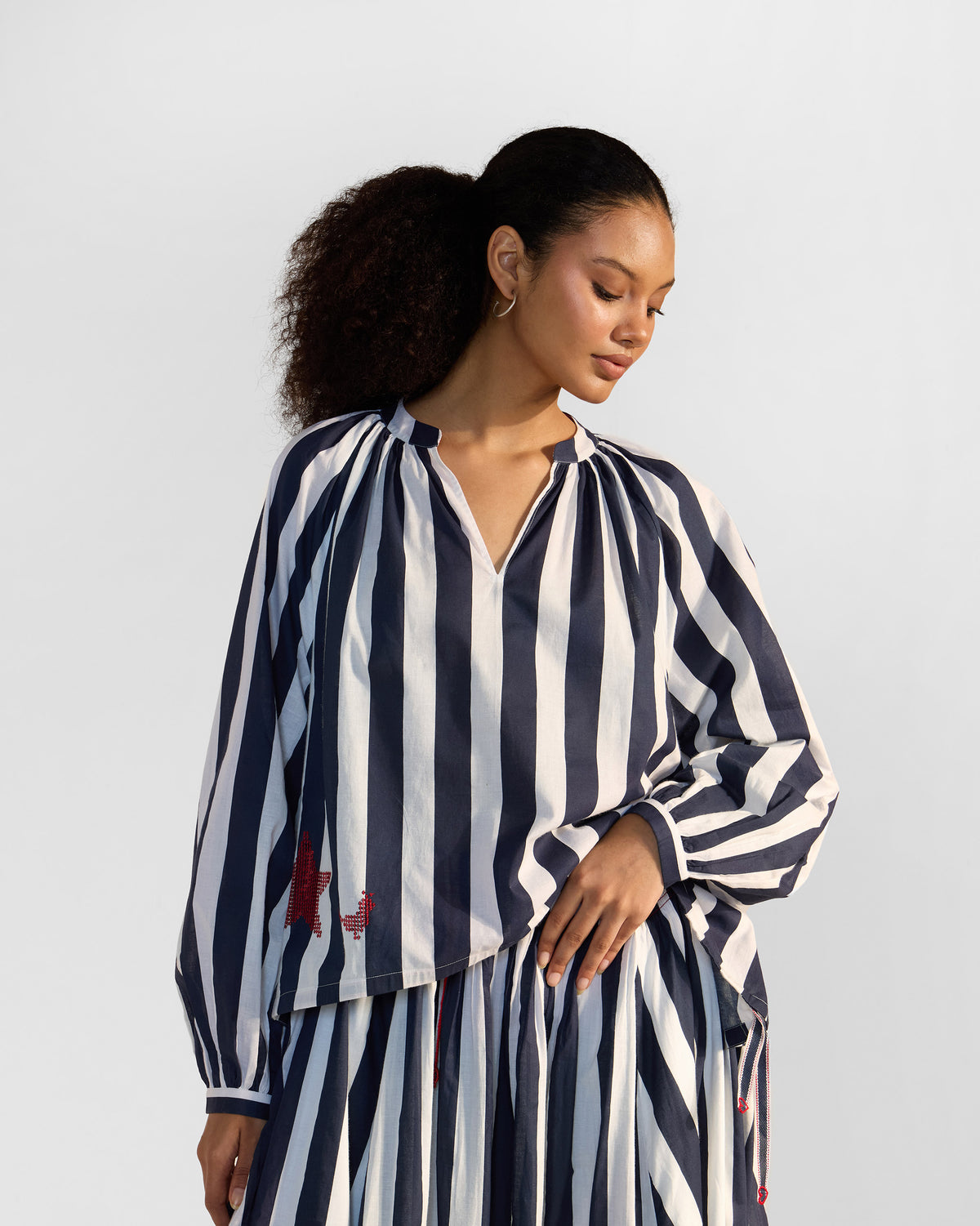 Navy and white striped Zaya top with voluminous sleeves and a red star.