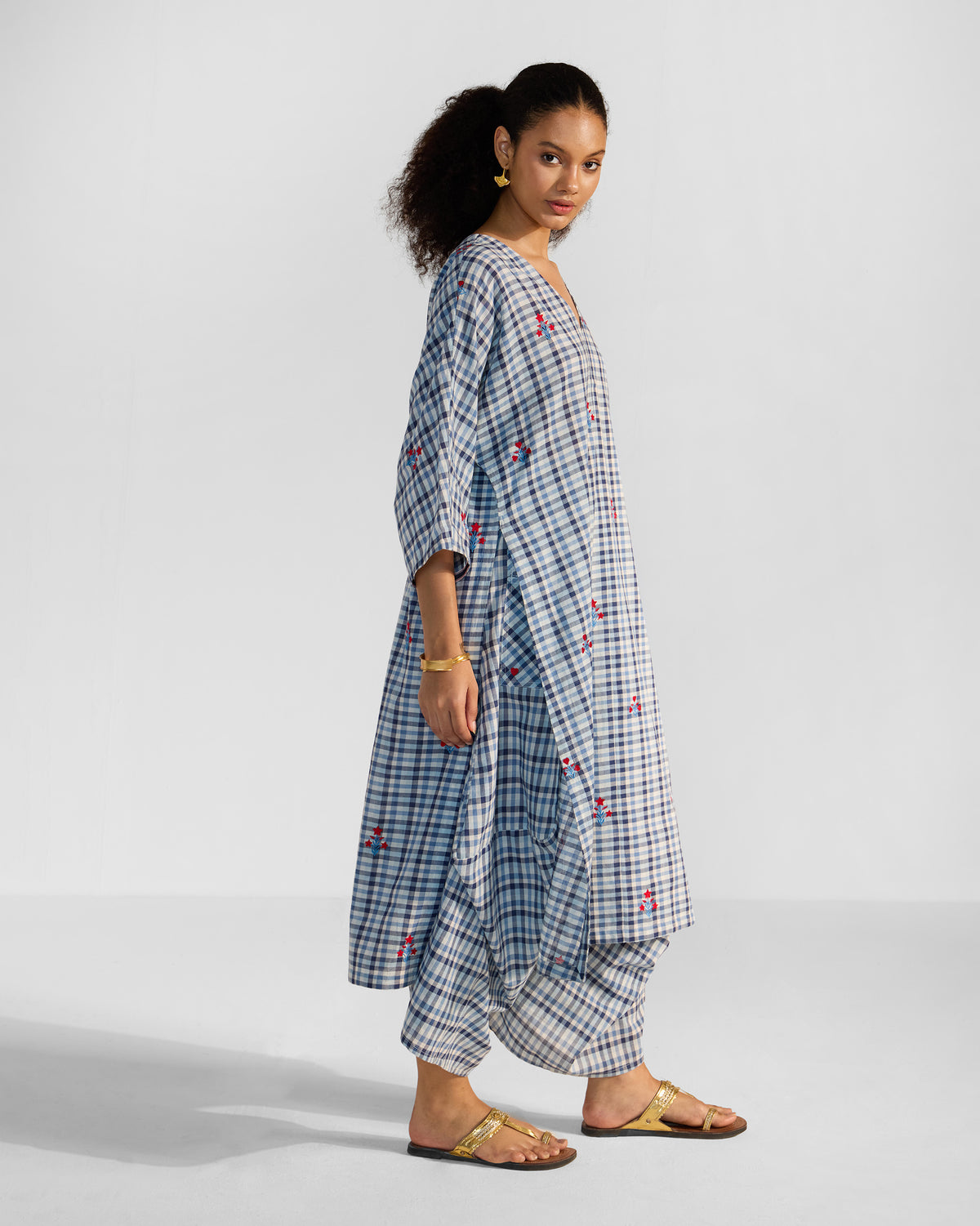 Side view of a blue and white check Aava kurta set with draped trousers.