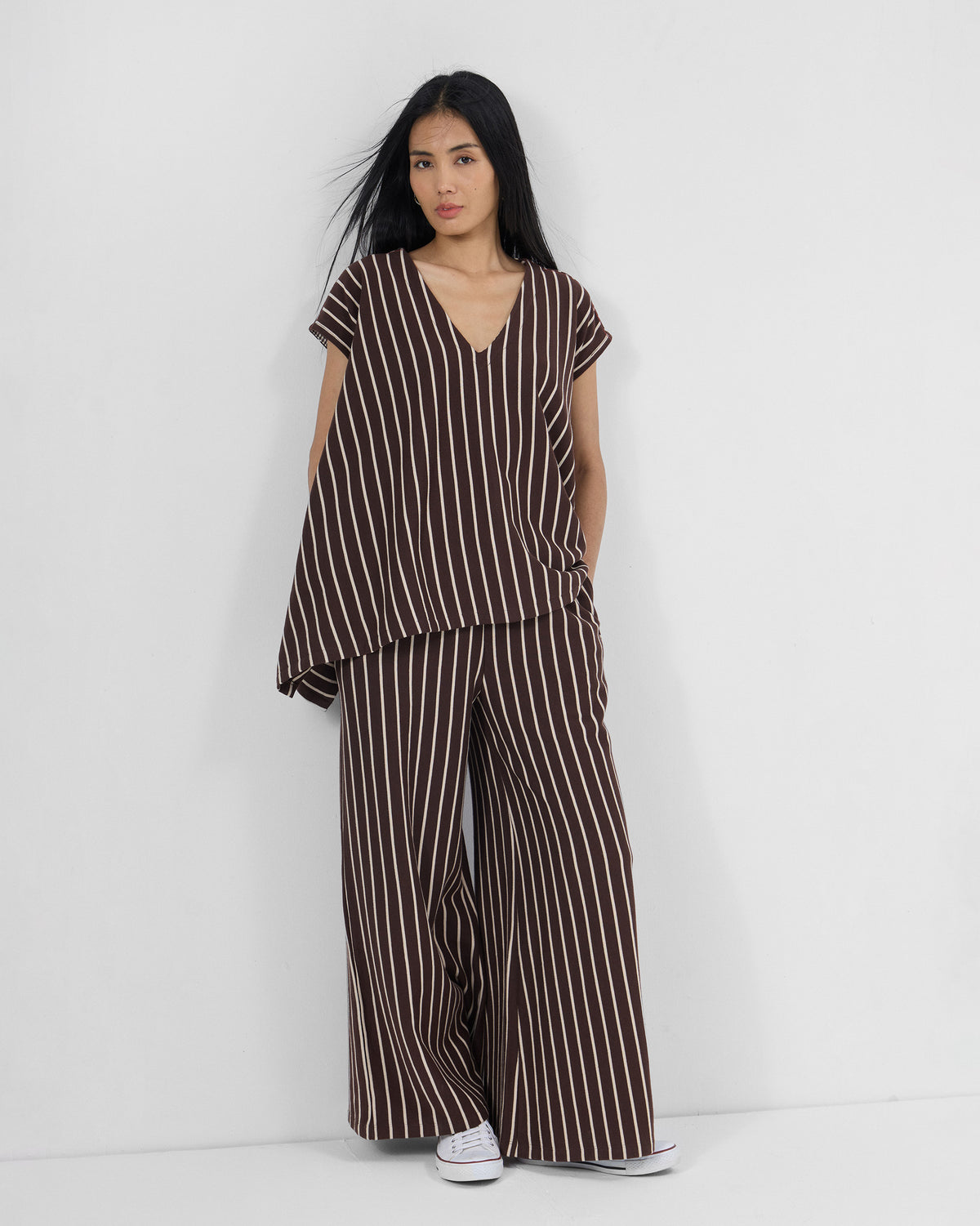 Person wearing a brown and ivory striped Nera kaftan top set with matching pants.
