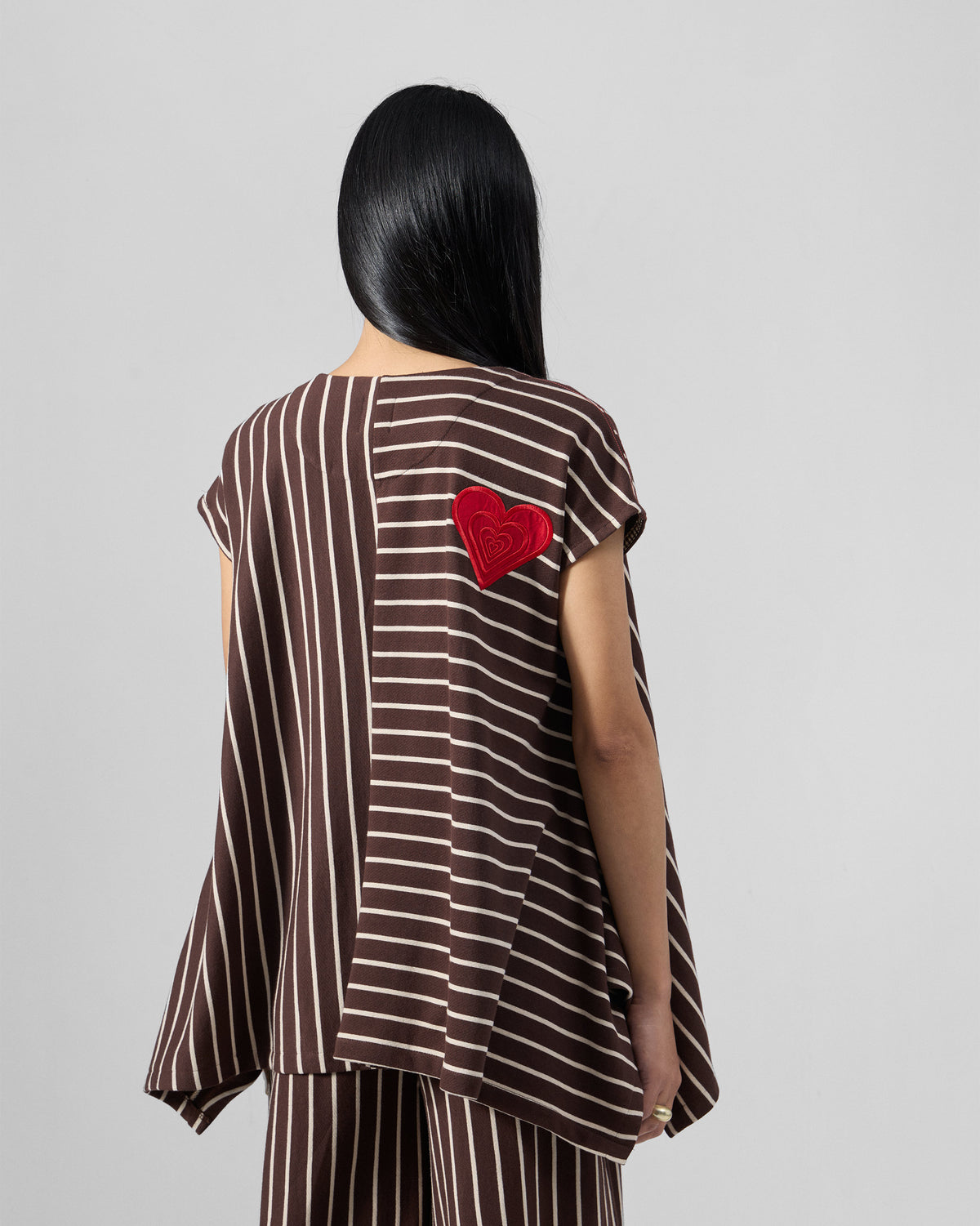 Back of a brown and ivory striped top with a red heart embroidery.