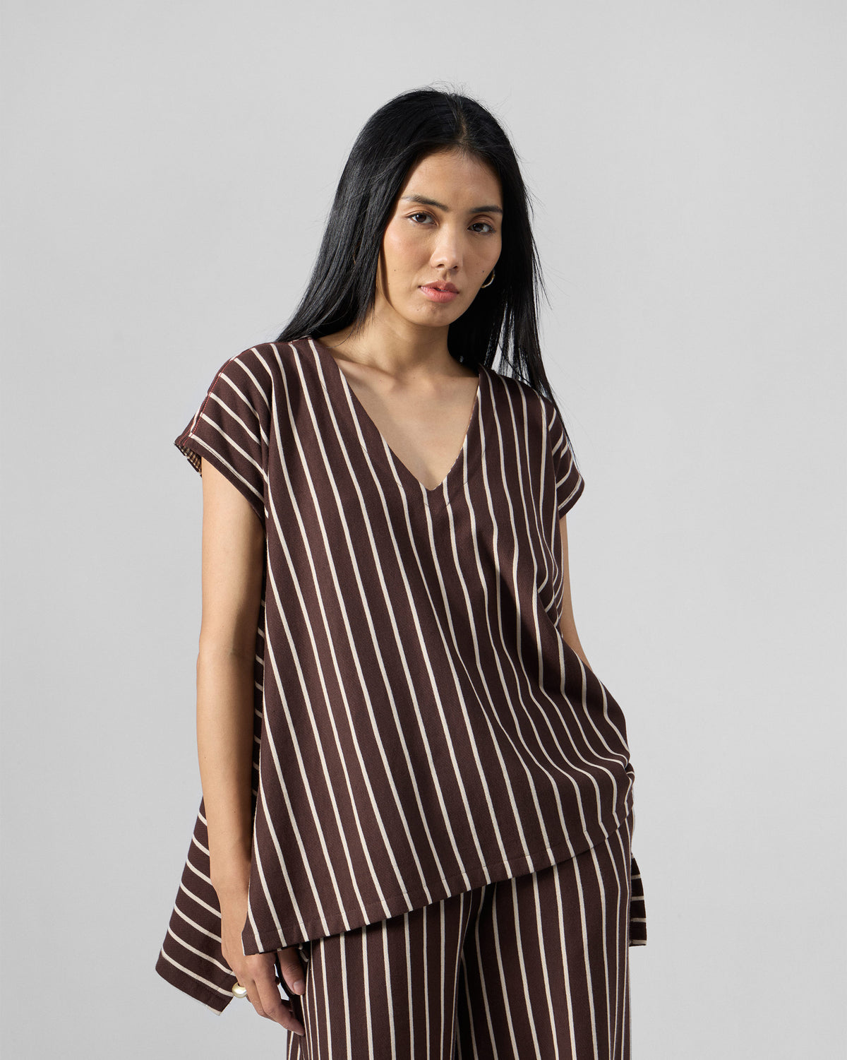 Person wearing a brown and ivory striped V-neck kaftan top with matching pants.
