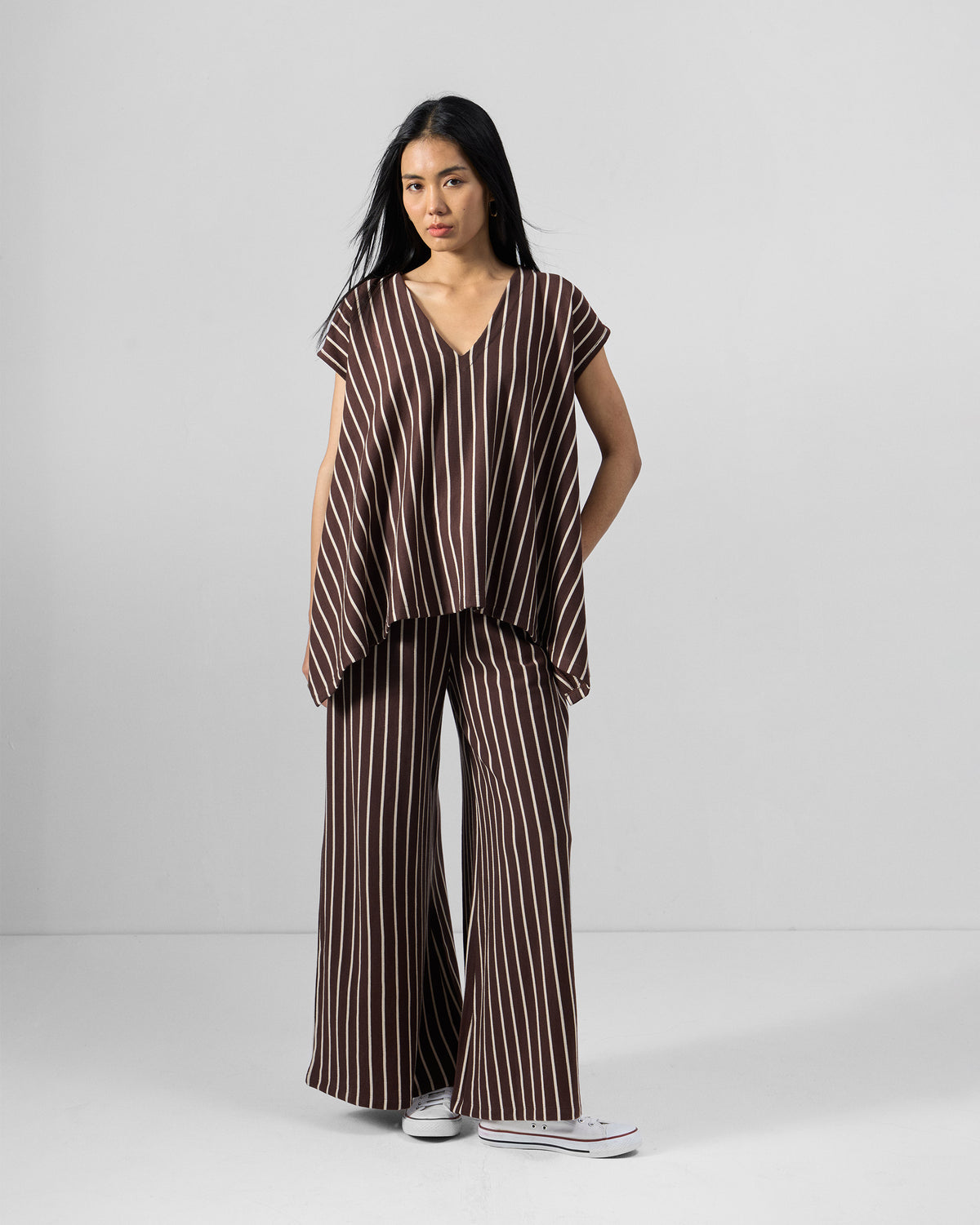Person wearing a brown and ivory striped kaftan top set with wide-leg pants.