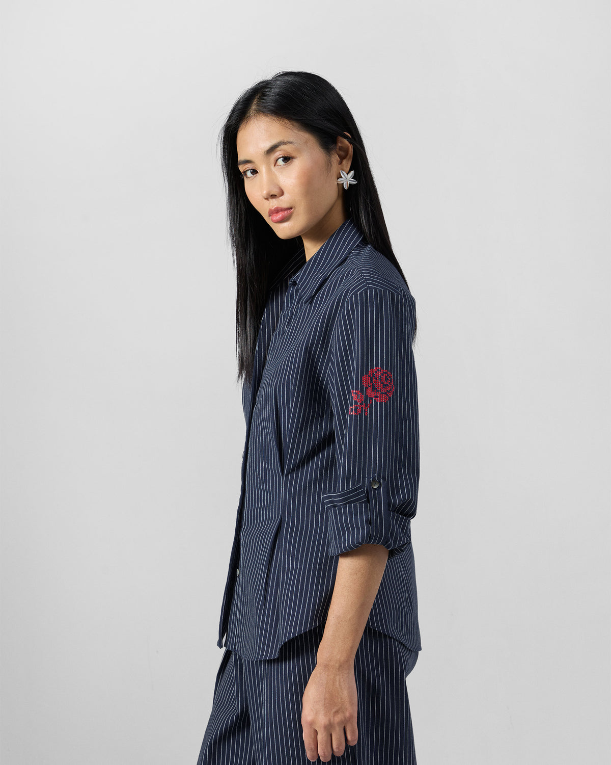 Side view of a navy pinstripe Kalo shirt with a red embroidered rose on the sleeve.