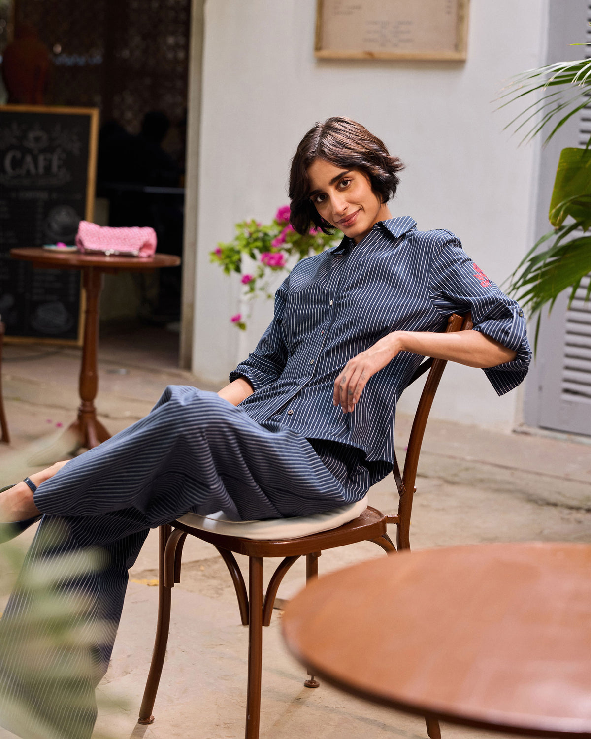 Person wearing a navy pinstripe Kalo Shirt Set while seated.