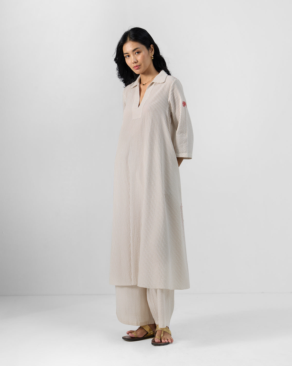 Person wearing a brown and ivory striped Maner Kurta Set with wide-leg pants.