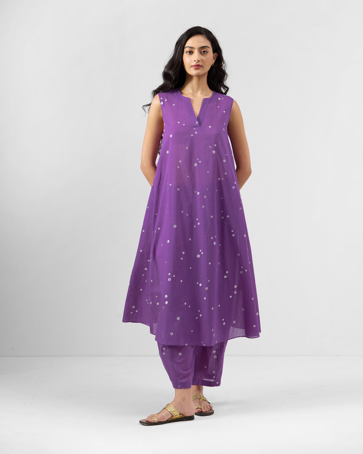 Person wearing a purple floral kurta set with matching pants.