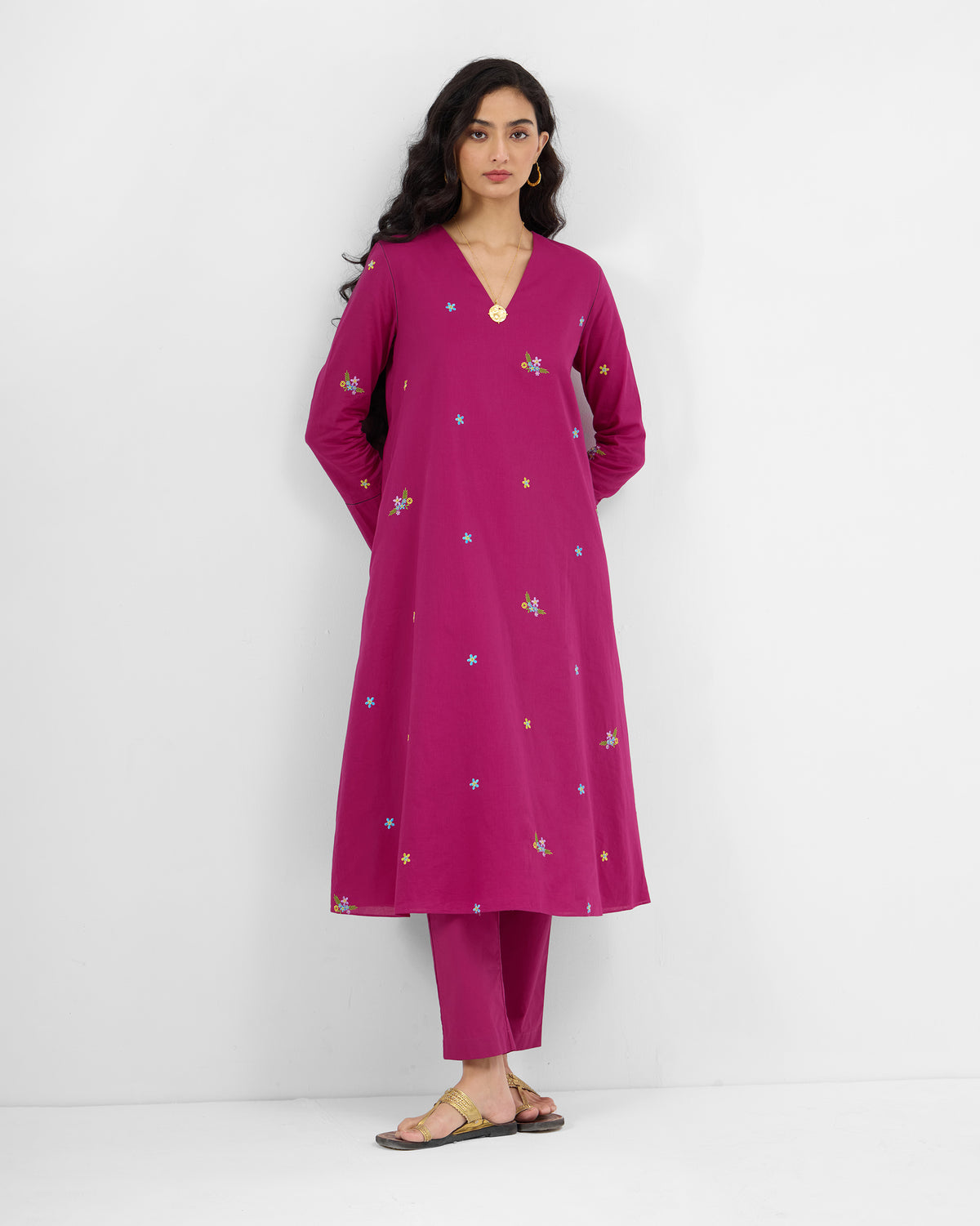 Person wearing a magenta Narsa Kurta Set with floral embroidery.