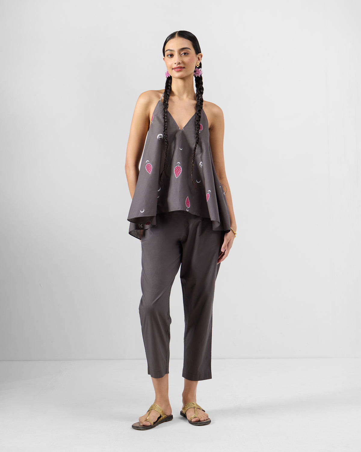 Person wearing a charcoal Daman top set with pink teardrop motifs and crescent moons.