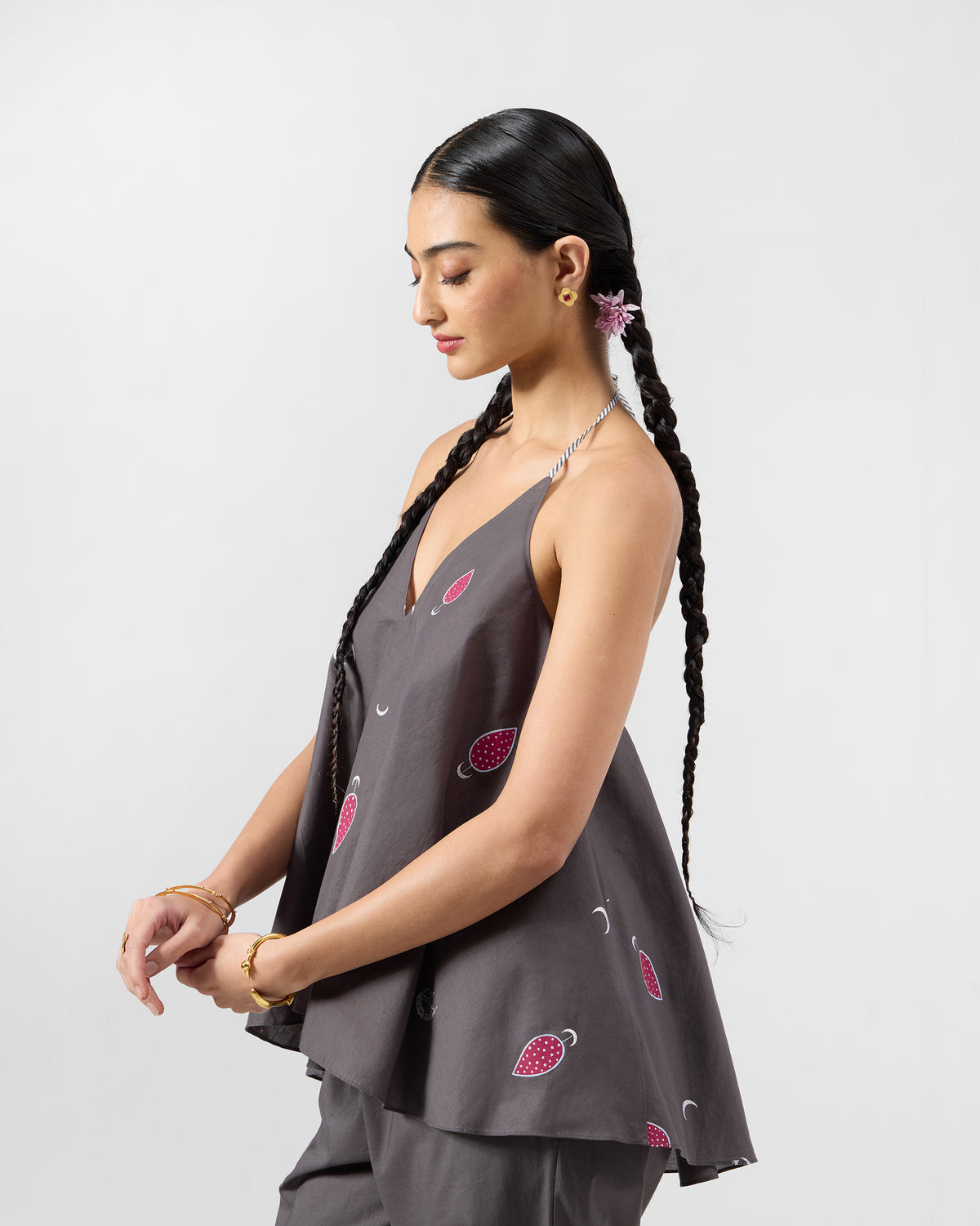 Side view of a charcoal Daman top with pink motifs and a flared hem.