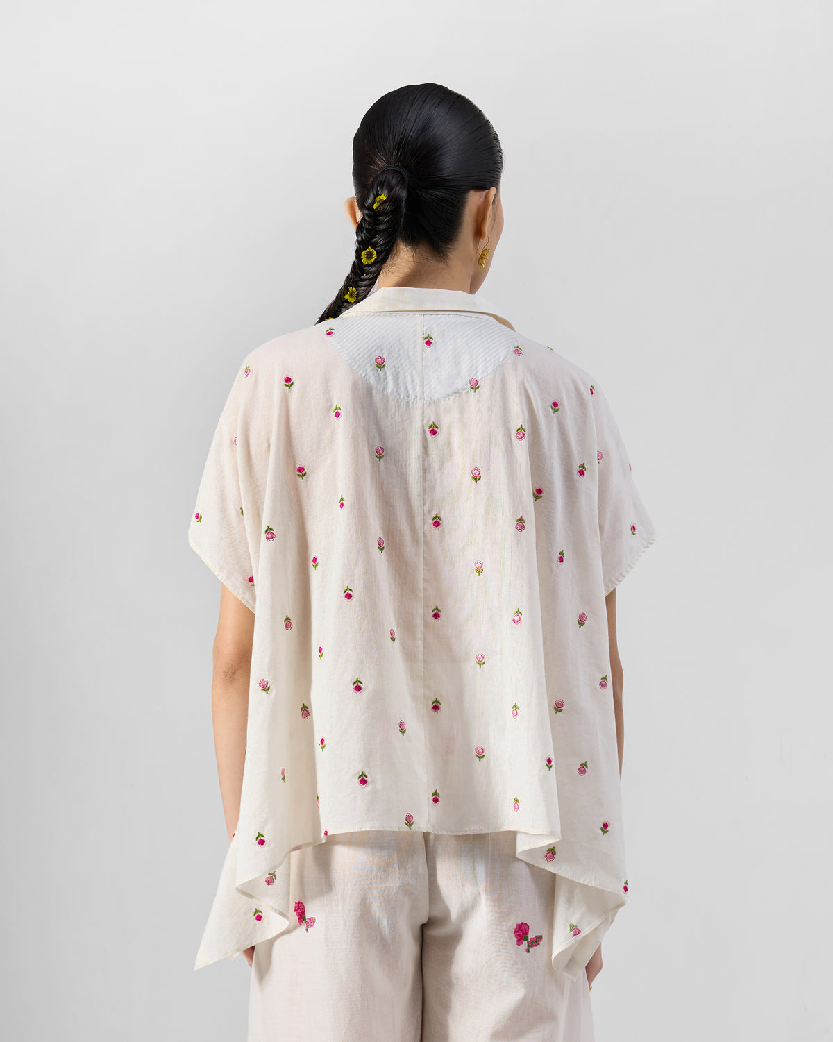 Back of an ivory embroidered shirt with a striped yoke and pink roses.