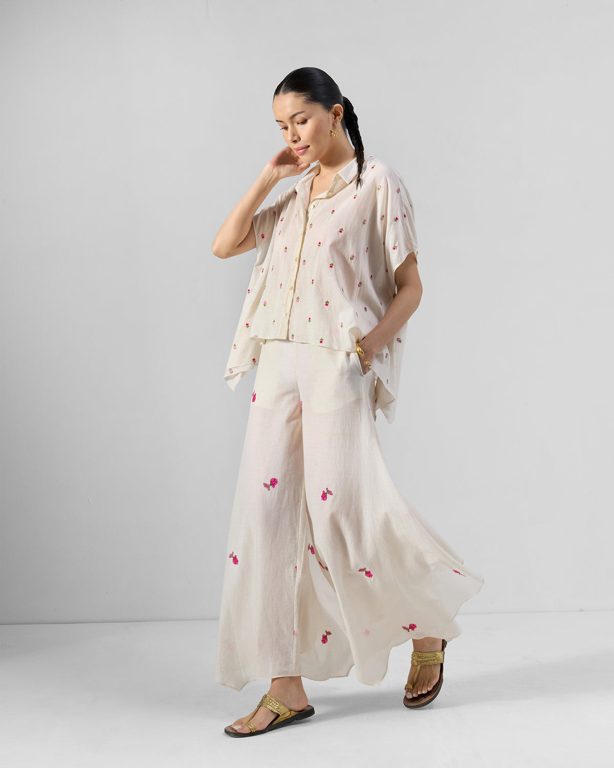 Person wearing an ivory embroidered shirt and wide-leg pants set.