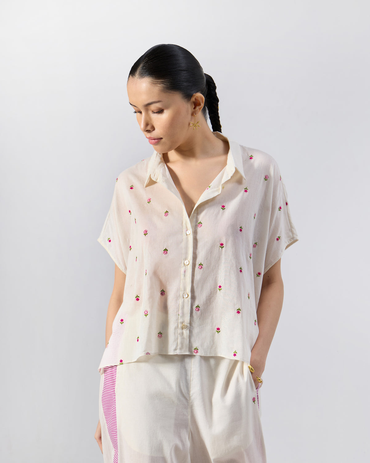Person wearing an ivory embroidered shirt with matching pants.