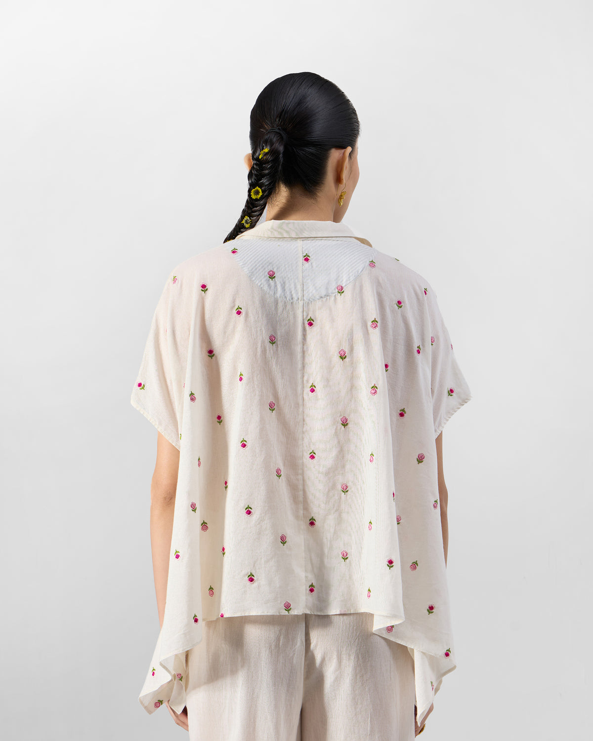 Back of an ivory embroidered shirt with pink rose motifs.