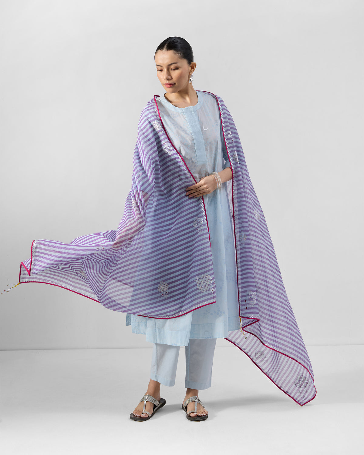 Person wearing a pale blue Kolva Kurta Set with a purple striped dupatta.