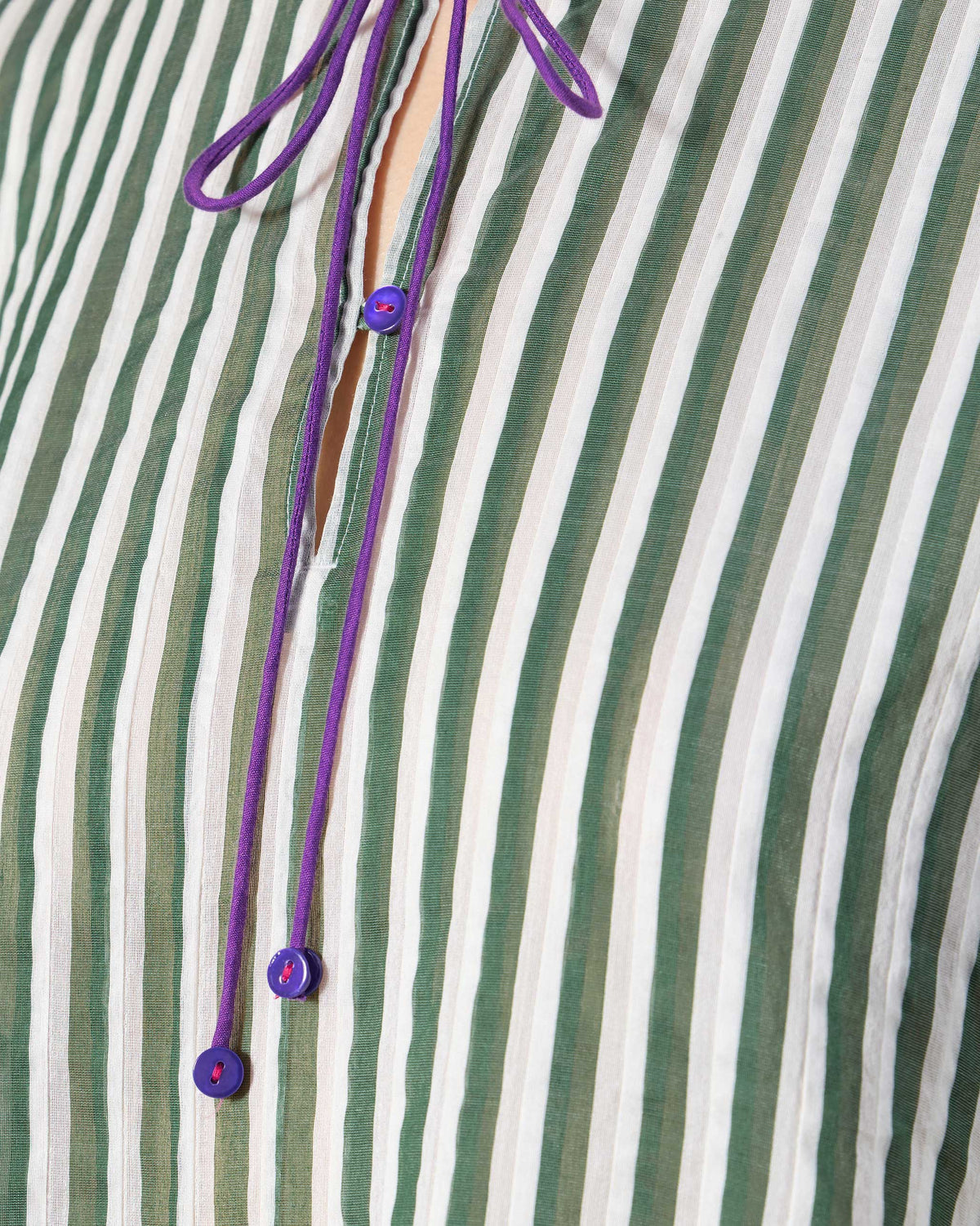 Close-up of a green striped kurta with purple neck ties.