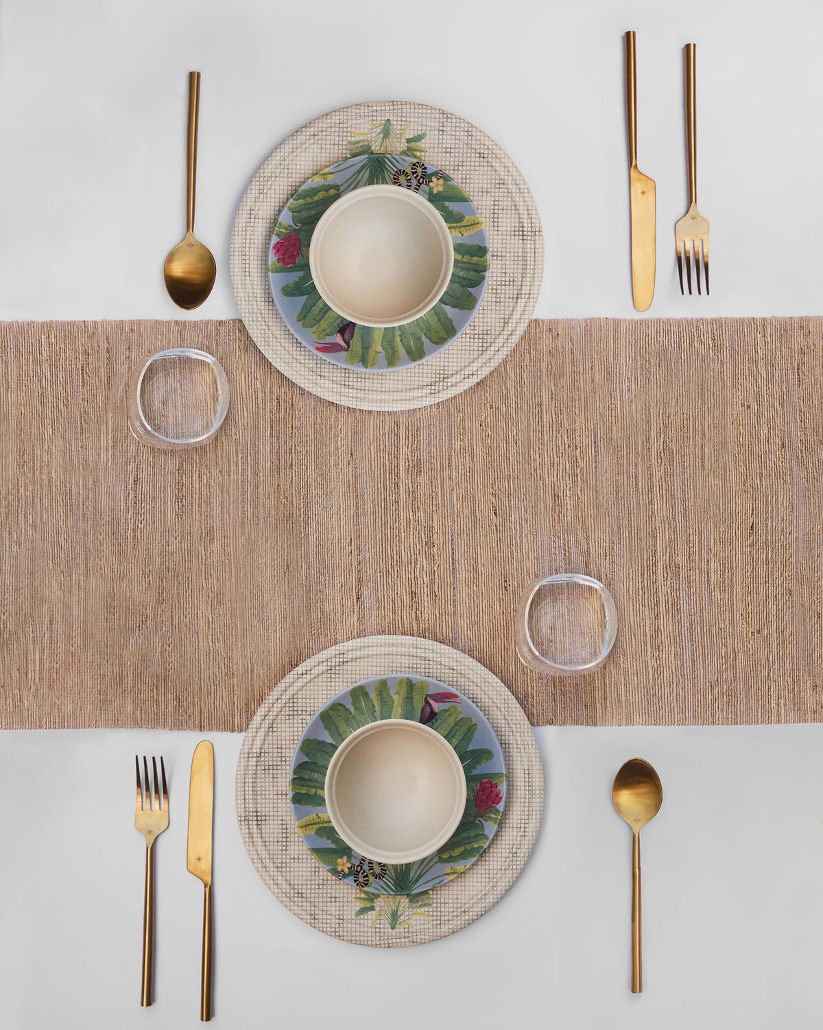 Madagascar dinner set for two with tropical plates and gold cutlery.
