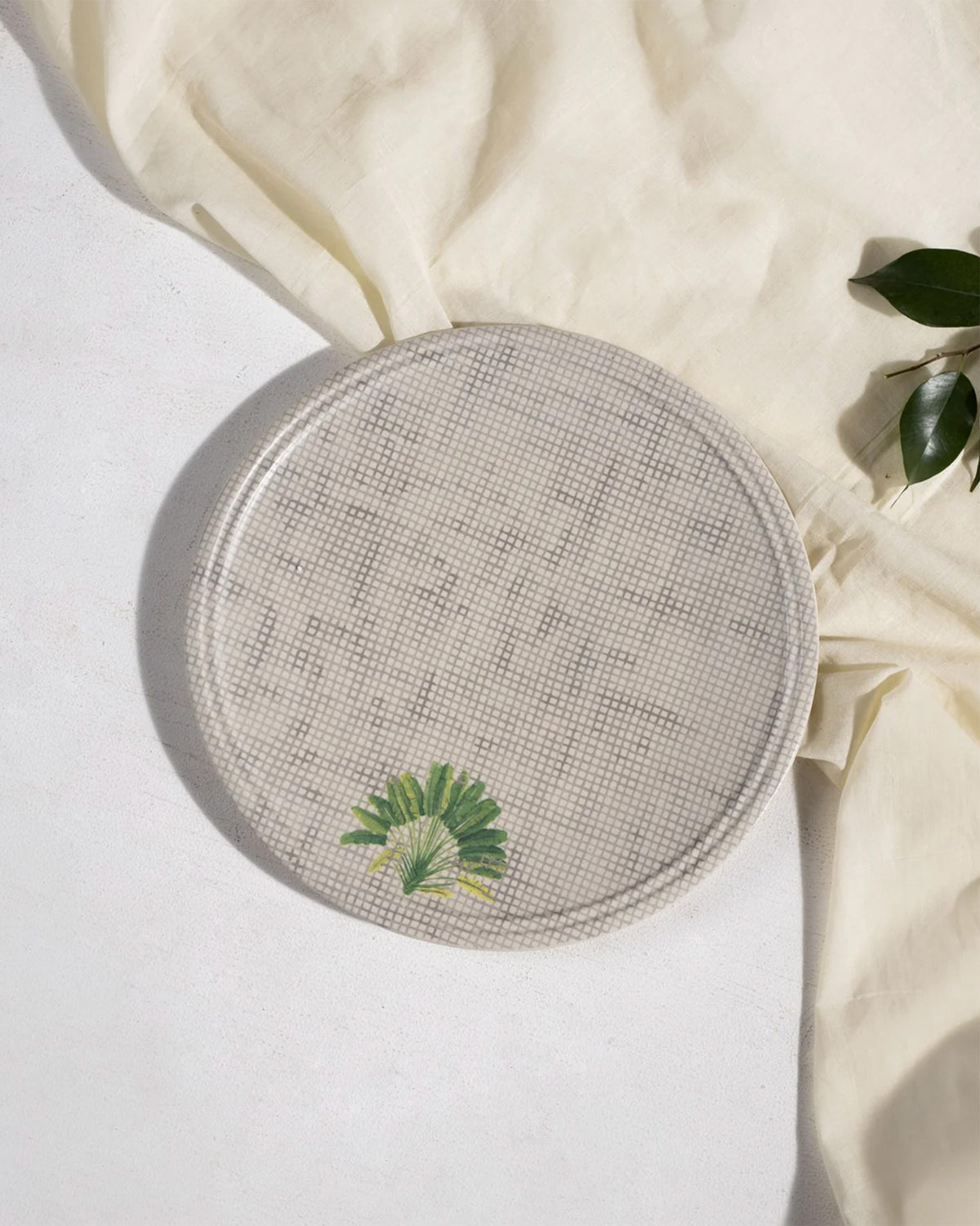 Madagascar dinner plate with cane texture and a small palm leaf.