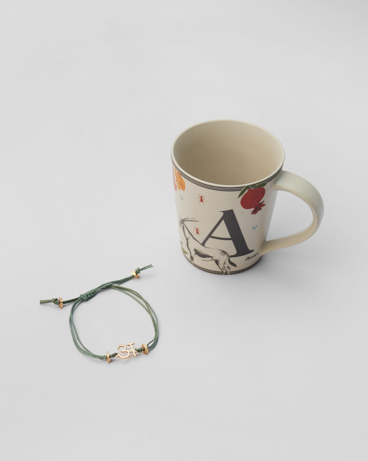 Ananas rakhi set with a gold letter A rakhi and matching mug.