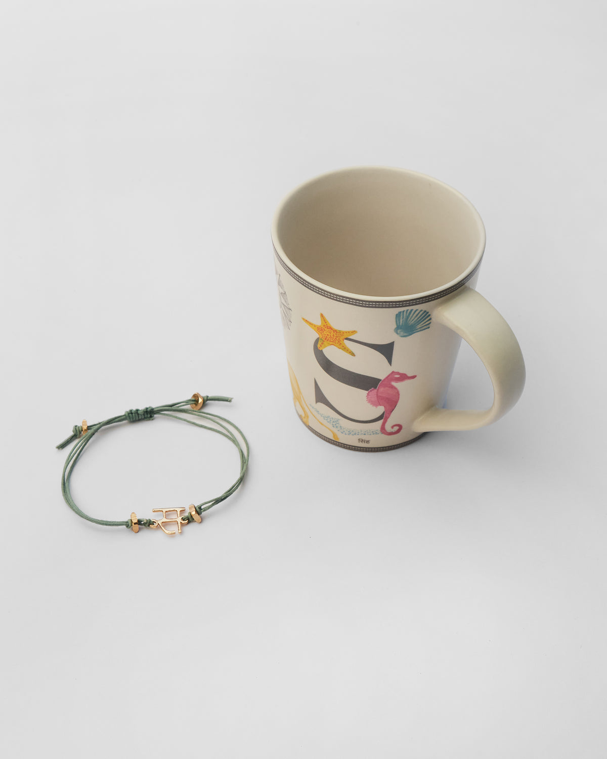Singha rakhi set with a gold letter S rakhi and matching mug.