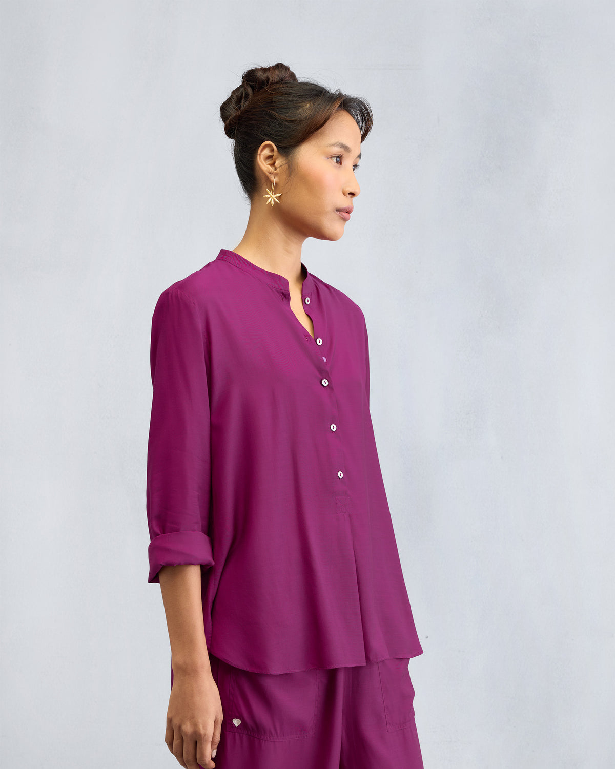 Side view of a mulberry mandarin collar top with a button placket.