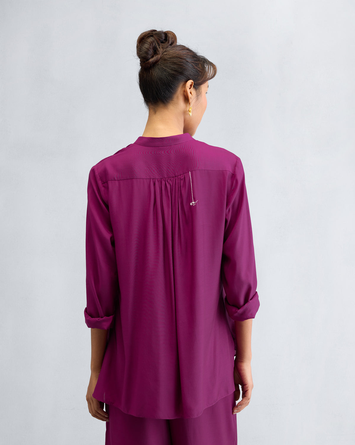Back of a mulberry mandarin collar top with a gathered yoke.
